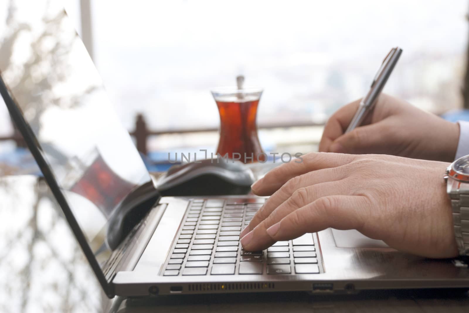 Close-up view of the hands on the keyboard while working with a businessman laptop.