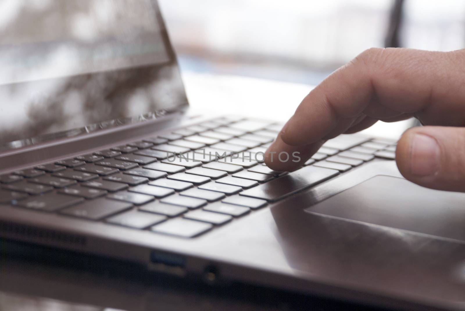 Close-up view of the hands on the keyboard while working with a businessman laptop.