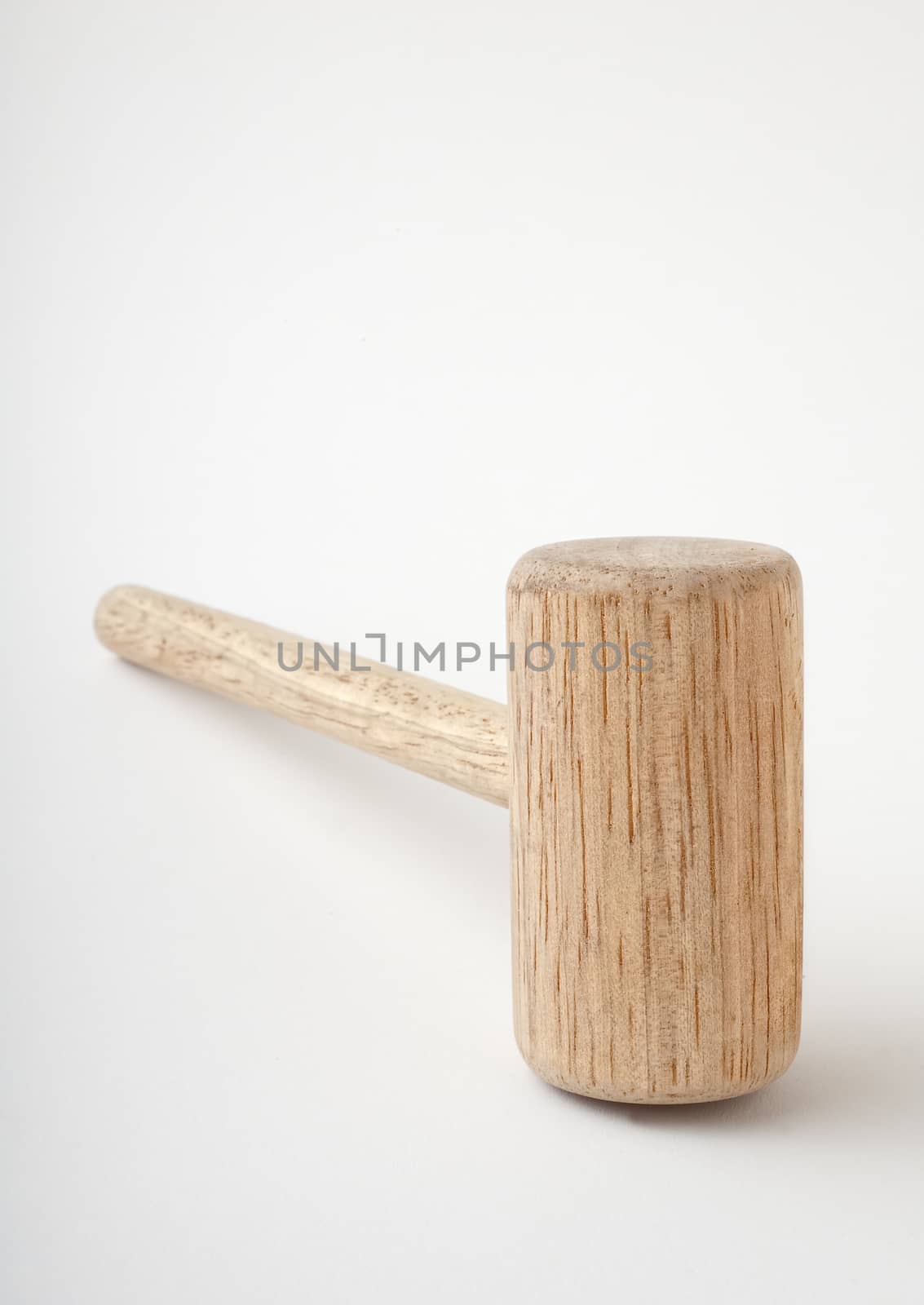 Wooden kitchen mallet lying on side, isolated white background