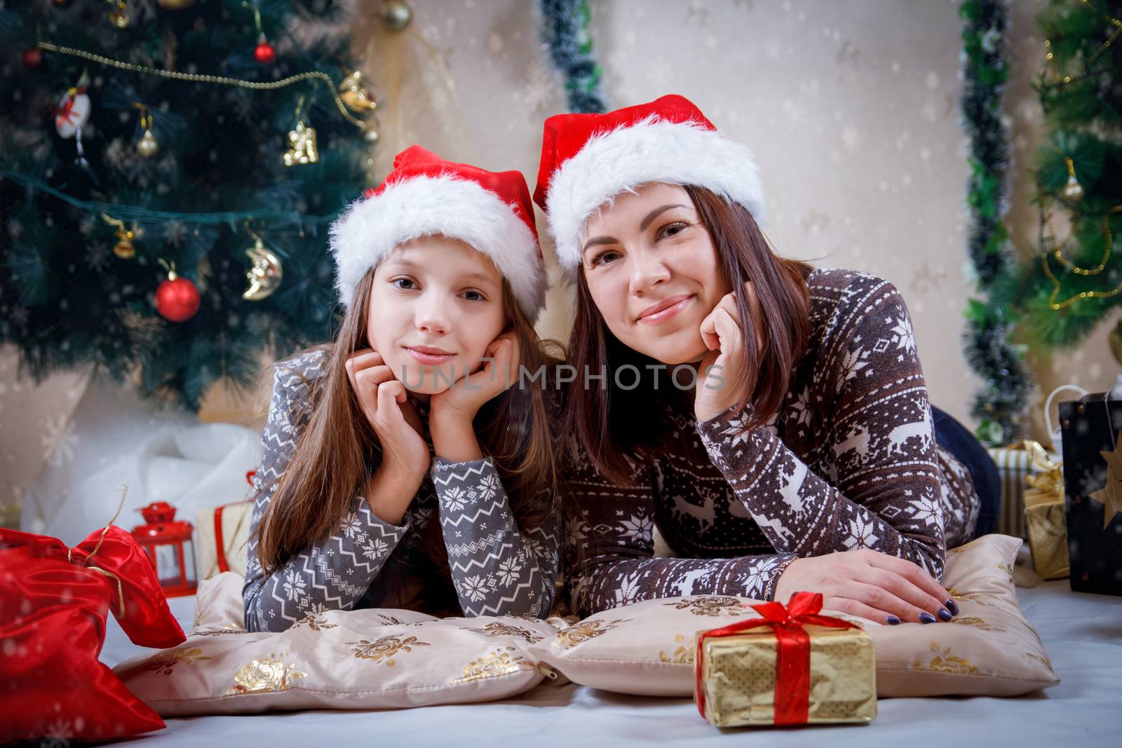 Mother and daughter lying under Christmas tree by Angel_a