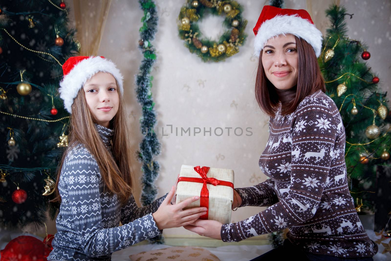 Mother and daughter holding Christmas gift by Angel_a