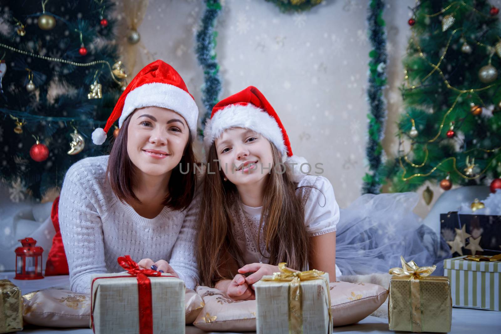 Mother and daughter lying in Christmas hats by Angel_a