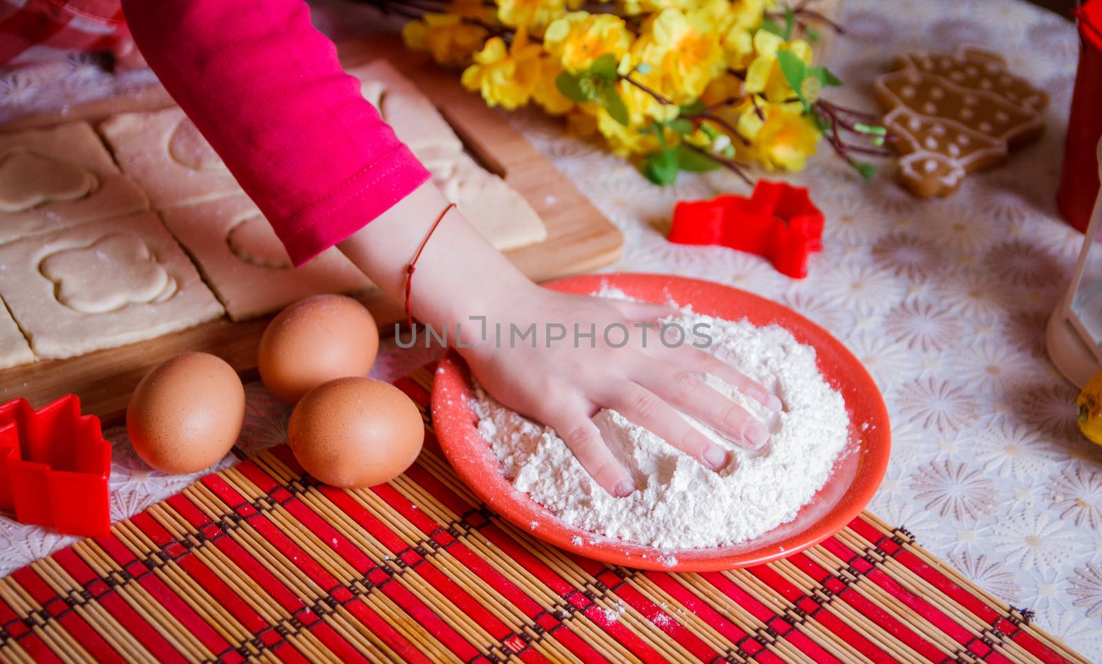 Little girl hand in flour cooking biscuits in kitchen