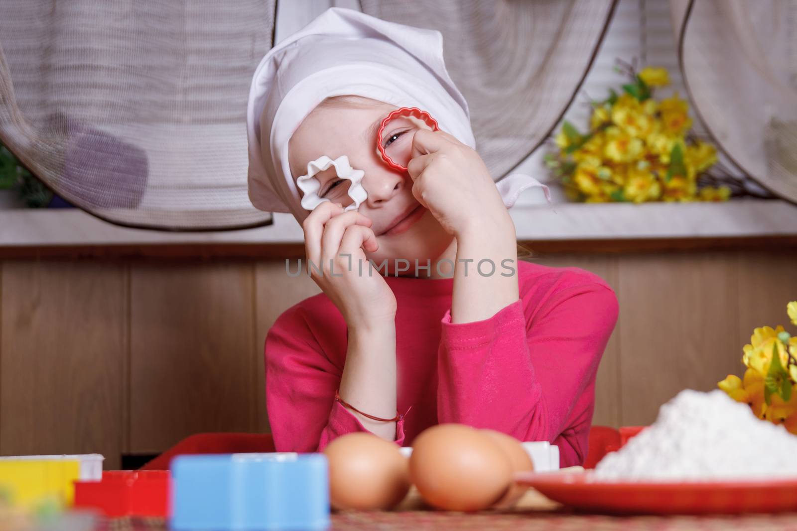 Happy girl having fun with form for cookies on kitchen