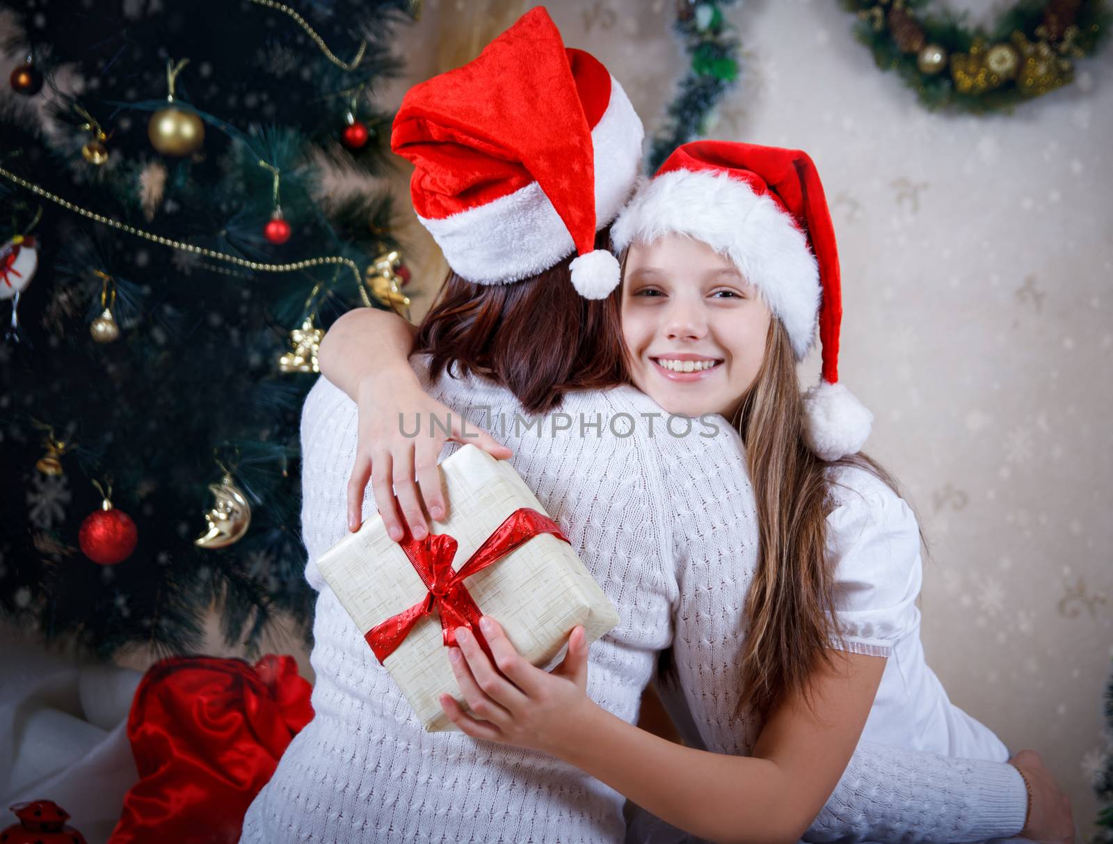 Girl hugging her mother with Christmas gift