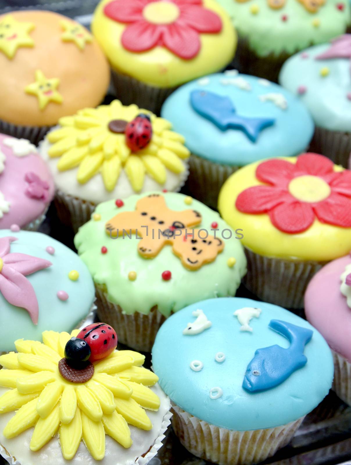 colorful cupcakes with various decorations, shallow dof