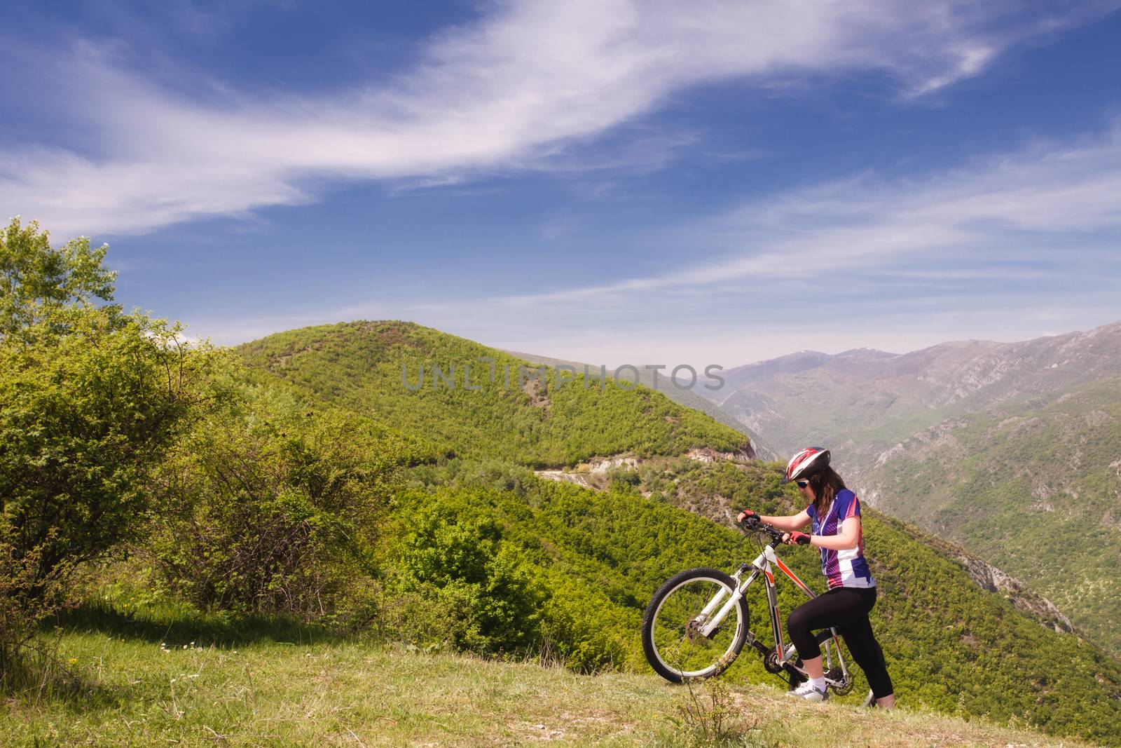 female mountainbiker pushing her mountainbike uphill