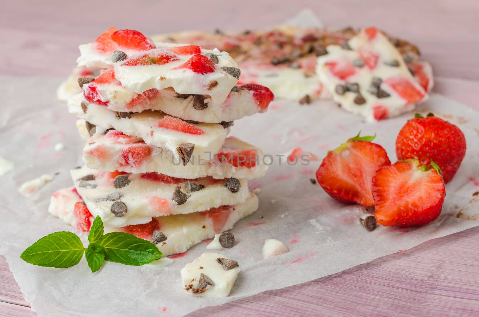 Homemade healthy frozen strawberry yogurt bark on rustic wooden  by AnaMarques