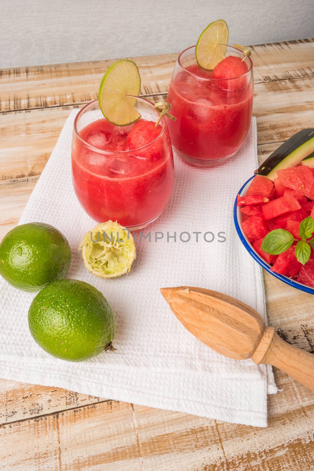 Watermelon fresh juice with mint leaves and lime citrus on wooden background