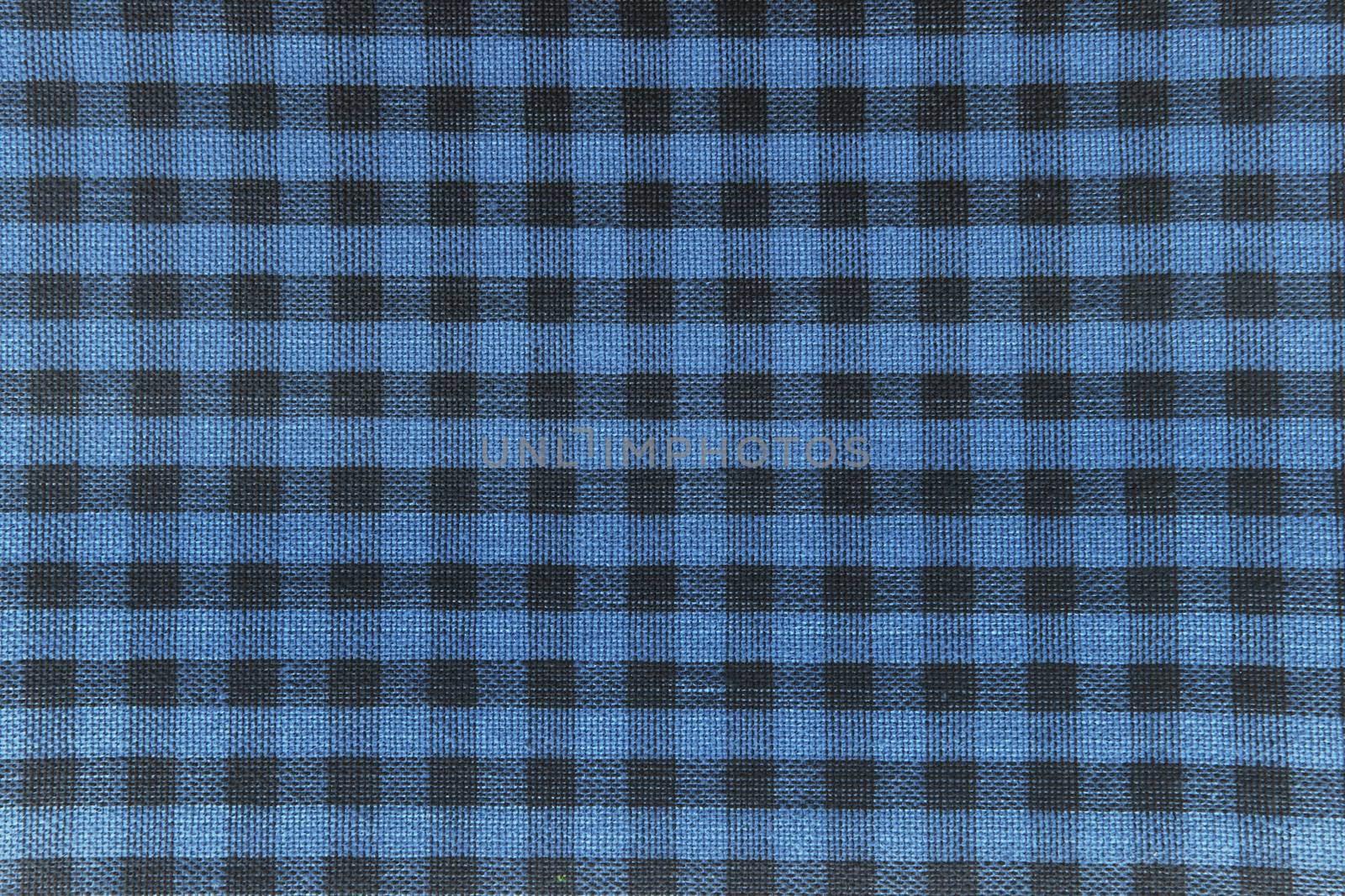 The texture of checkered fabric as a background. Checked fabric tablecloth. Fabric in a small square. Texture plaid fabric. Texture background of kitchen towels