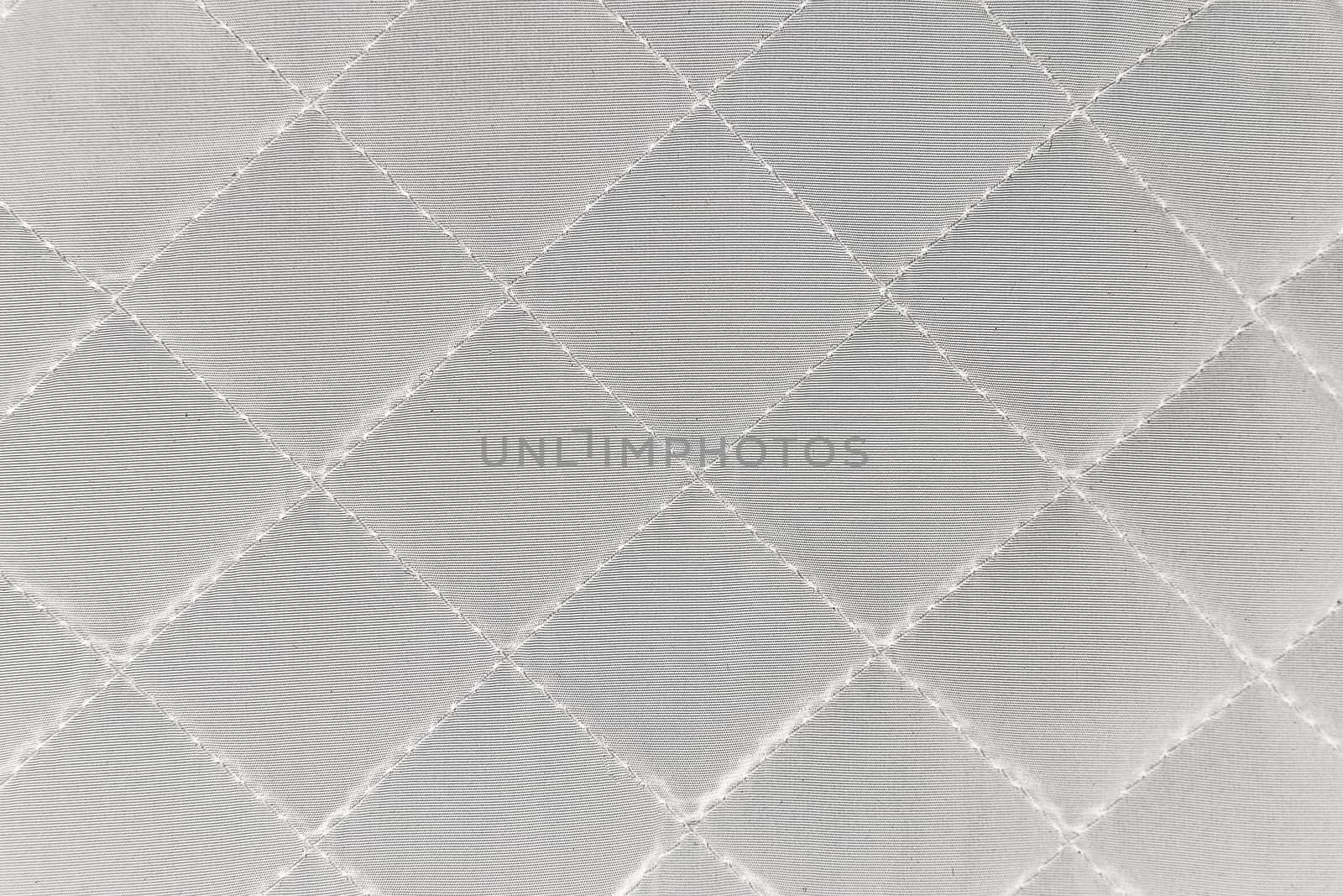 Cloth in rhombus. Quilted synthetic fabric texture background.