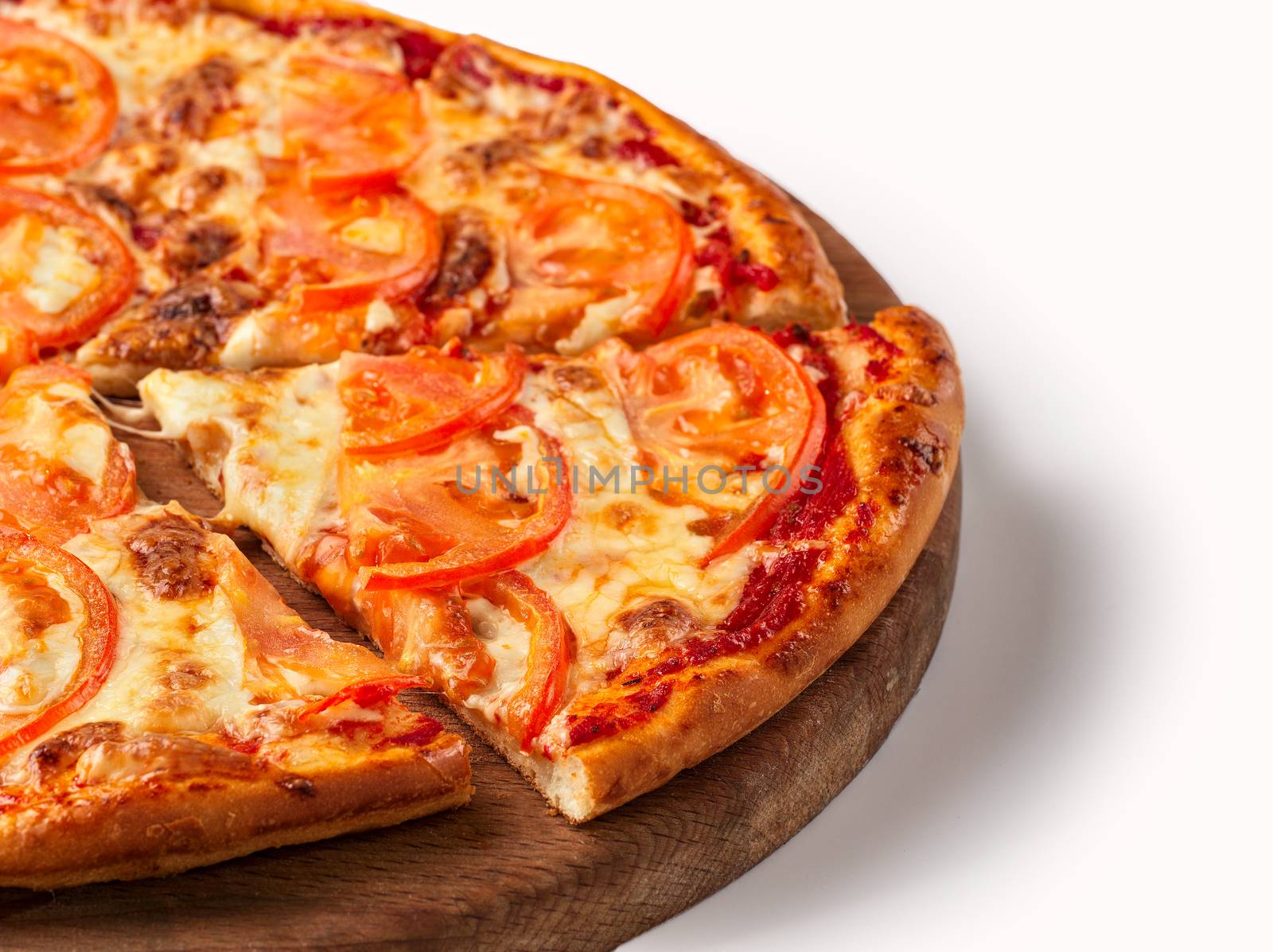 Close up view on piece of pizza with tomato and cheese on wooden cutting board. Isolated on white with clipping path