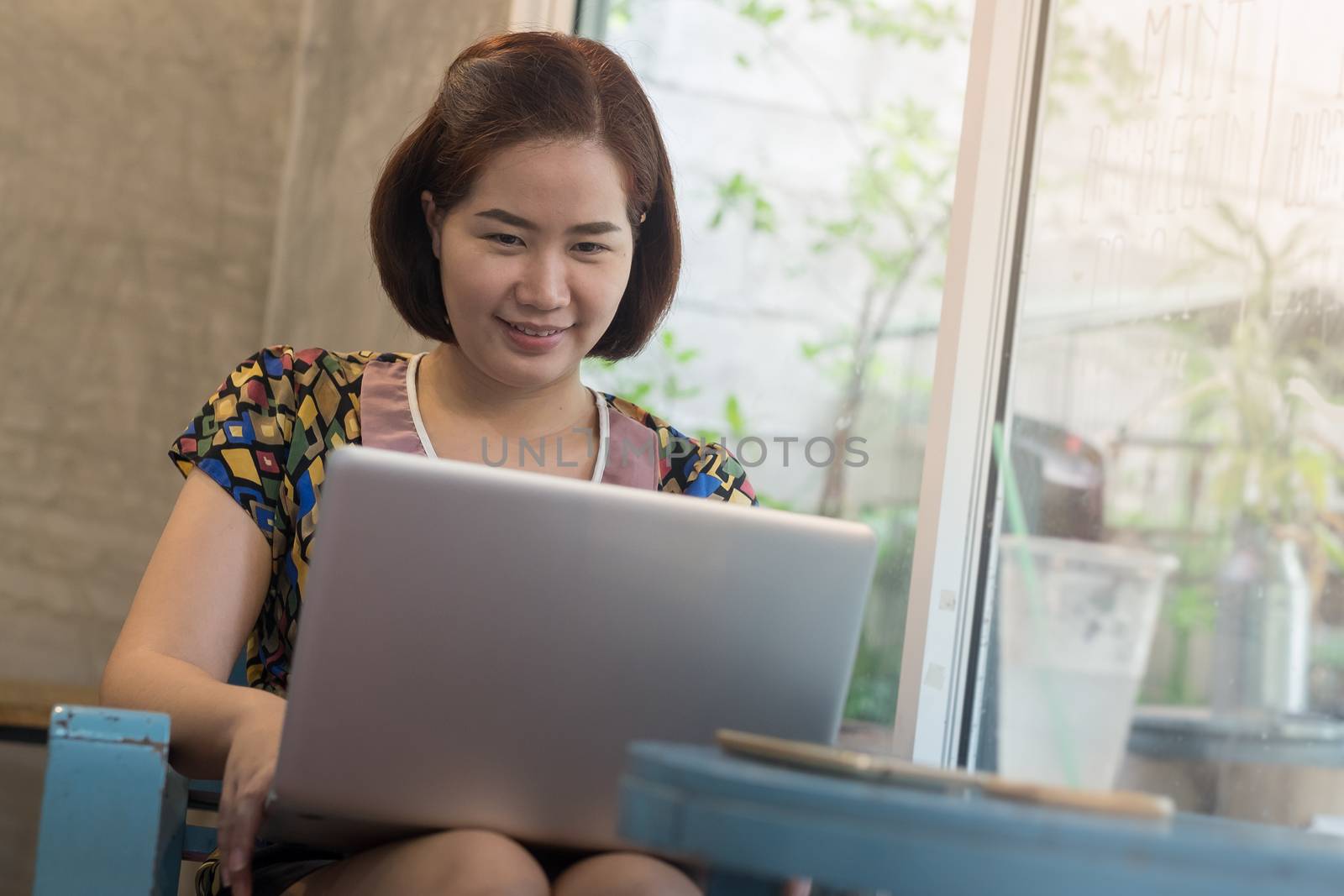 Young Asian woman working online at home with laptop computer. Freelance and outsource worker activity concept.