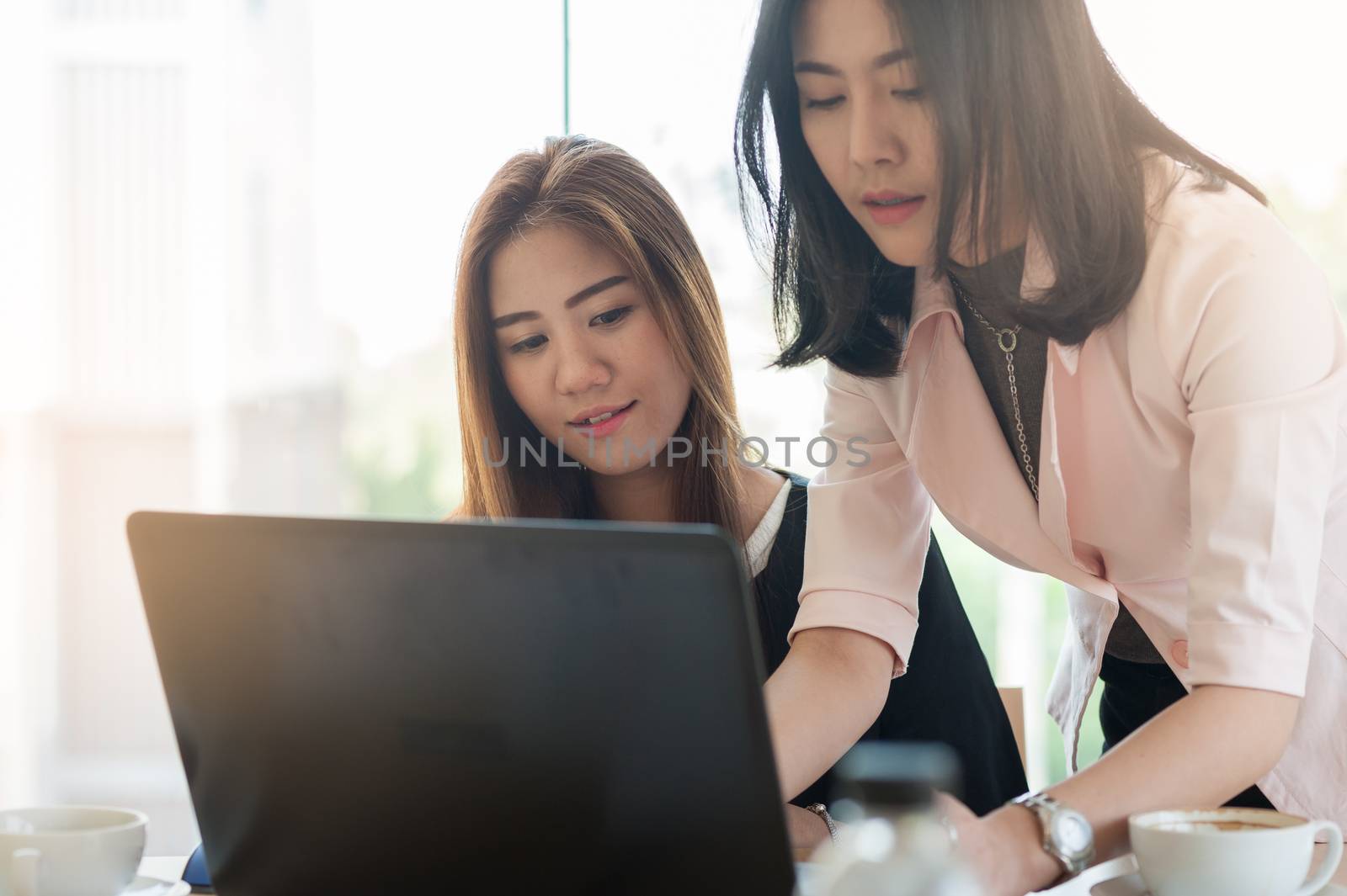 Young Asian business workers working together with laptop computer in office. Business startup teamwork and brainstorm concept