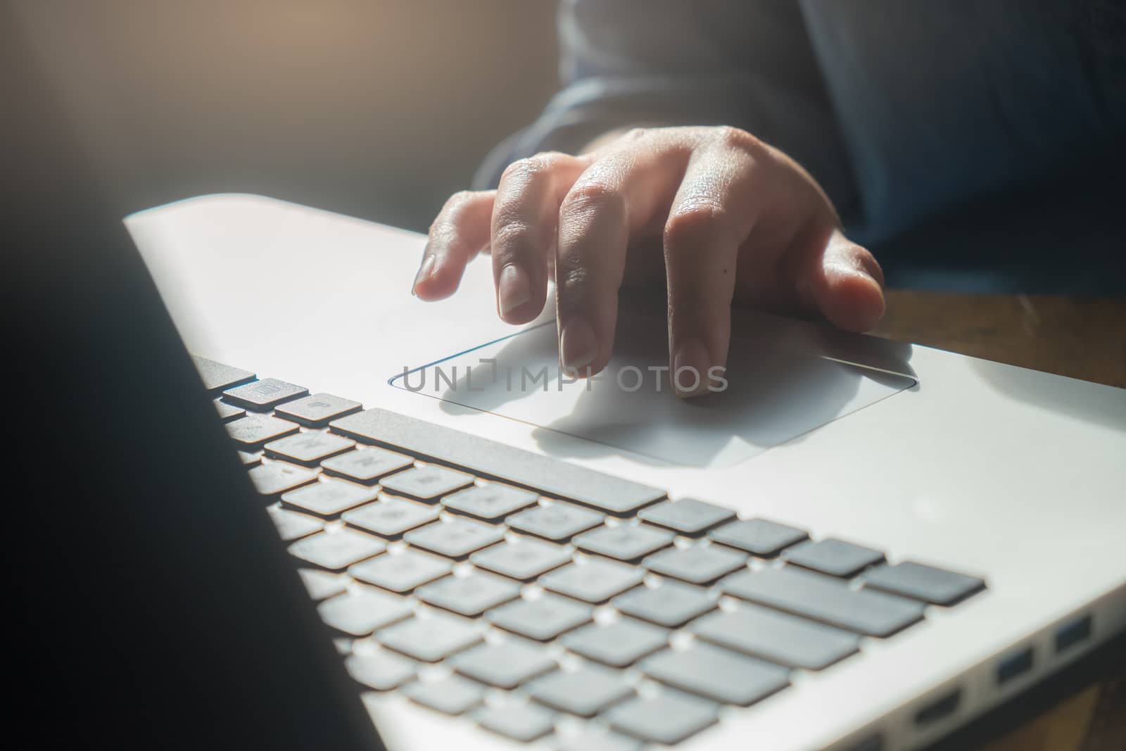 Woman freelance worker touching on laptop touch pad by her hand to select something while working in cafe on weekday morning. Freelance business working lifestyle concept