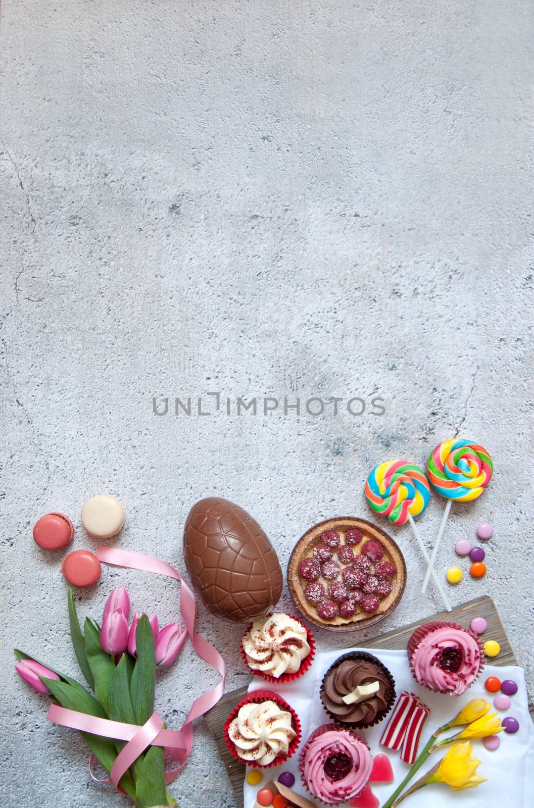 Assorted easter sweets, bakery cupcakes, chocolate eggs and confectionery with background space 