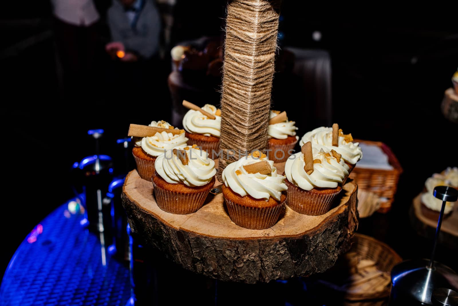 Holiday candy bar. Candy bar served with cupcakes with cream and biscuits on wooden stump by d_duda