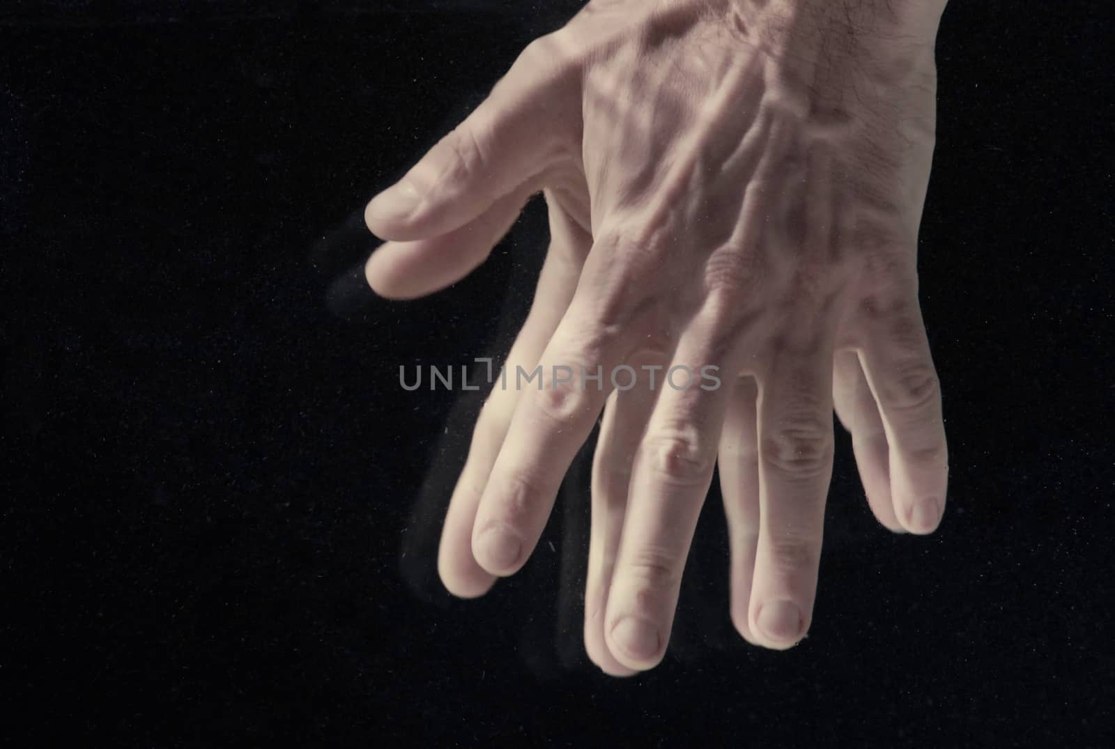 Man's hands under water on black background