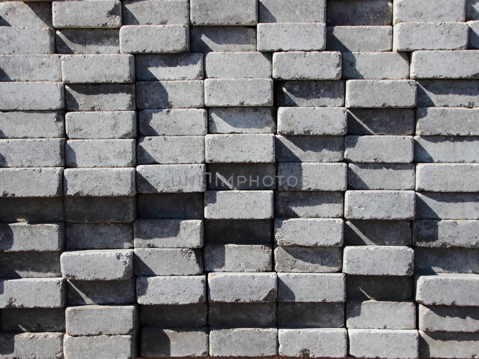 Uneven Stack of Grey Concrete Road Bricks Background