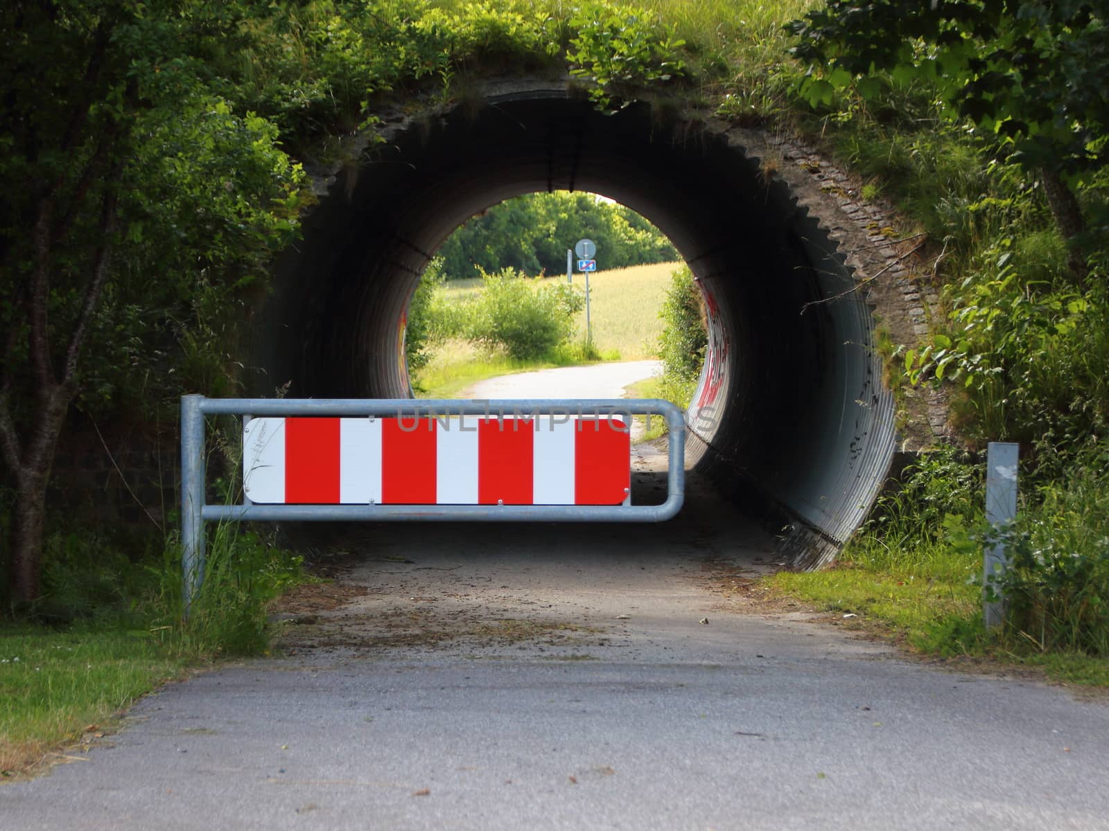 Bicycle and Pedestrian Tunnel with Red and White Car Barrier