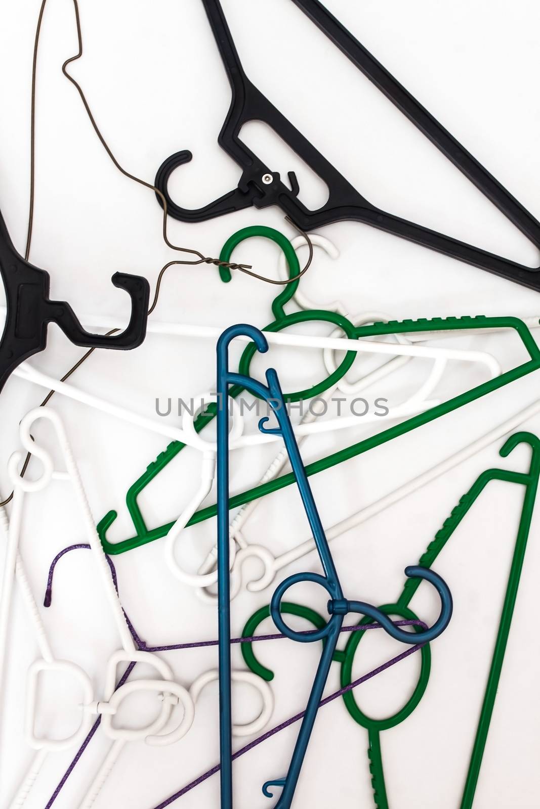 Many hangers of different shapes and colors, top view, white background.