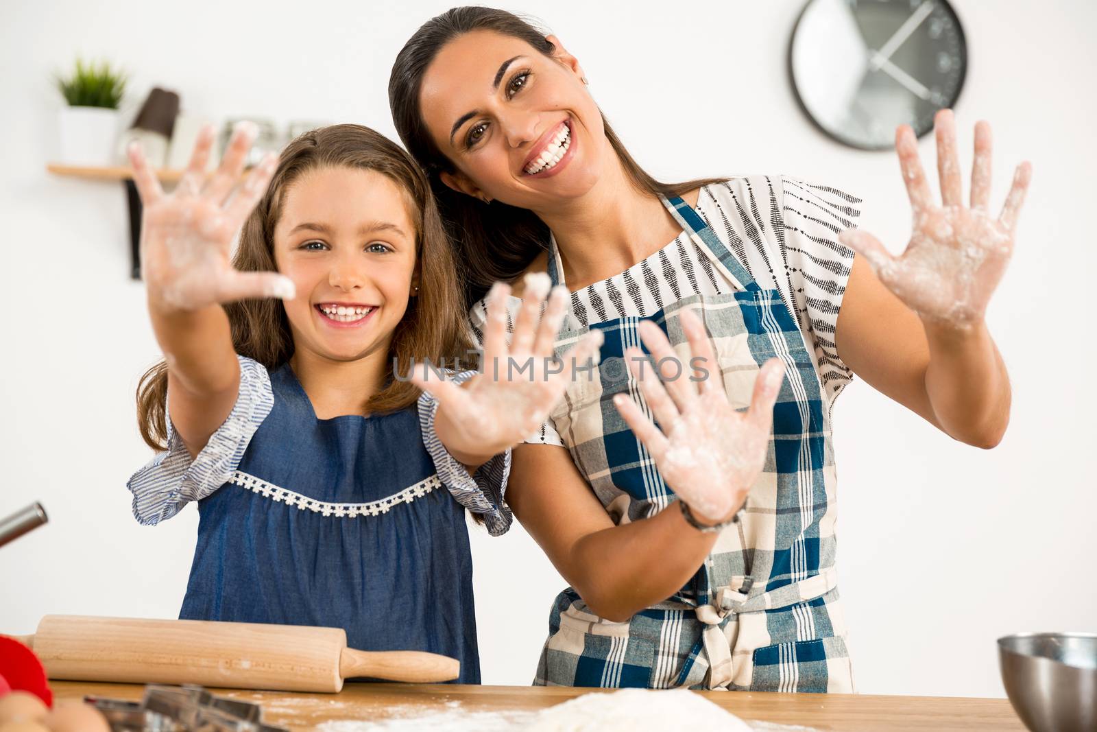 Shot of a mother and daughter having fun in the kitchen and learning to make a cake