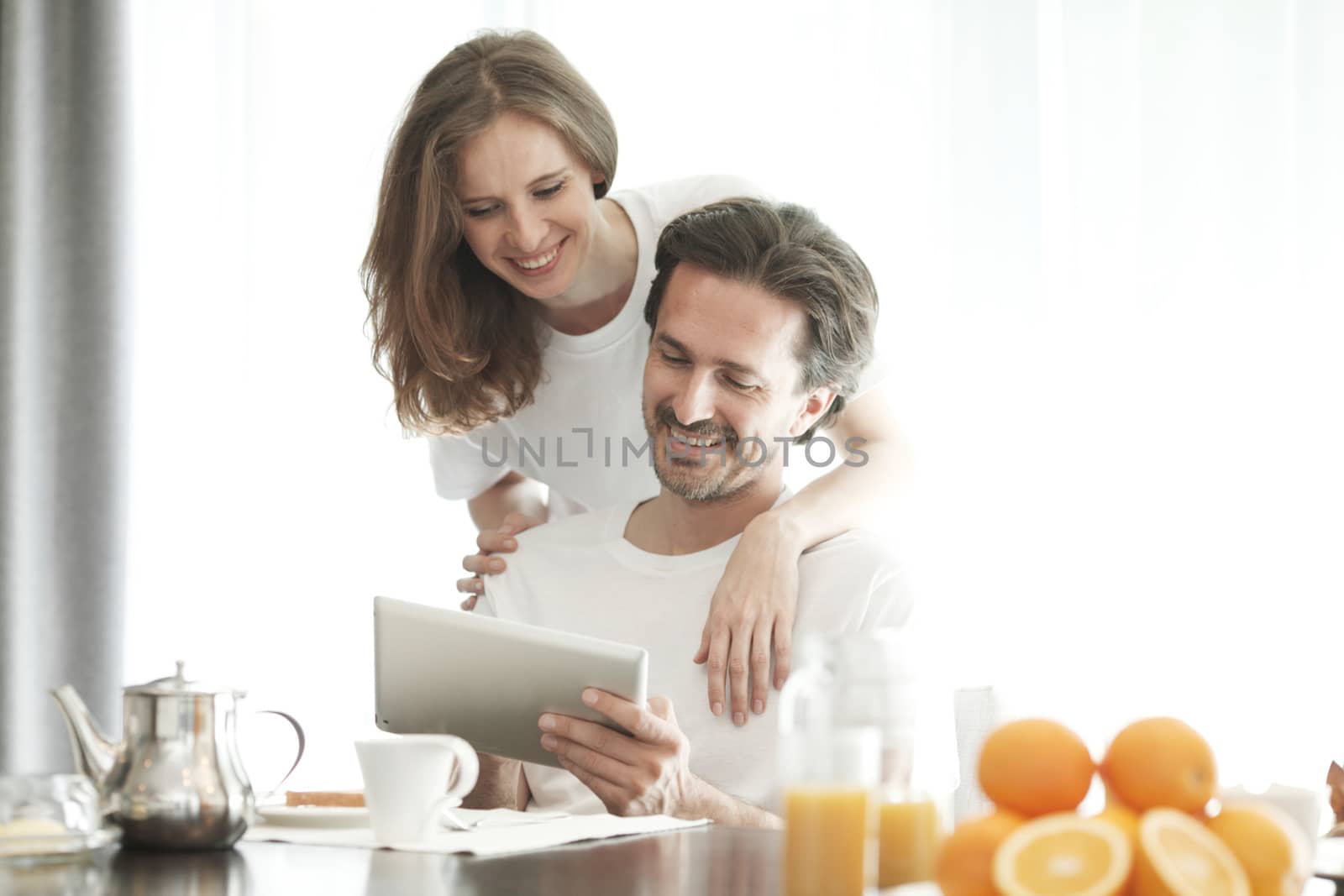 Couple using tablet during breakfast by ALotOfPeople