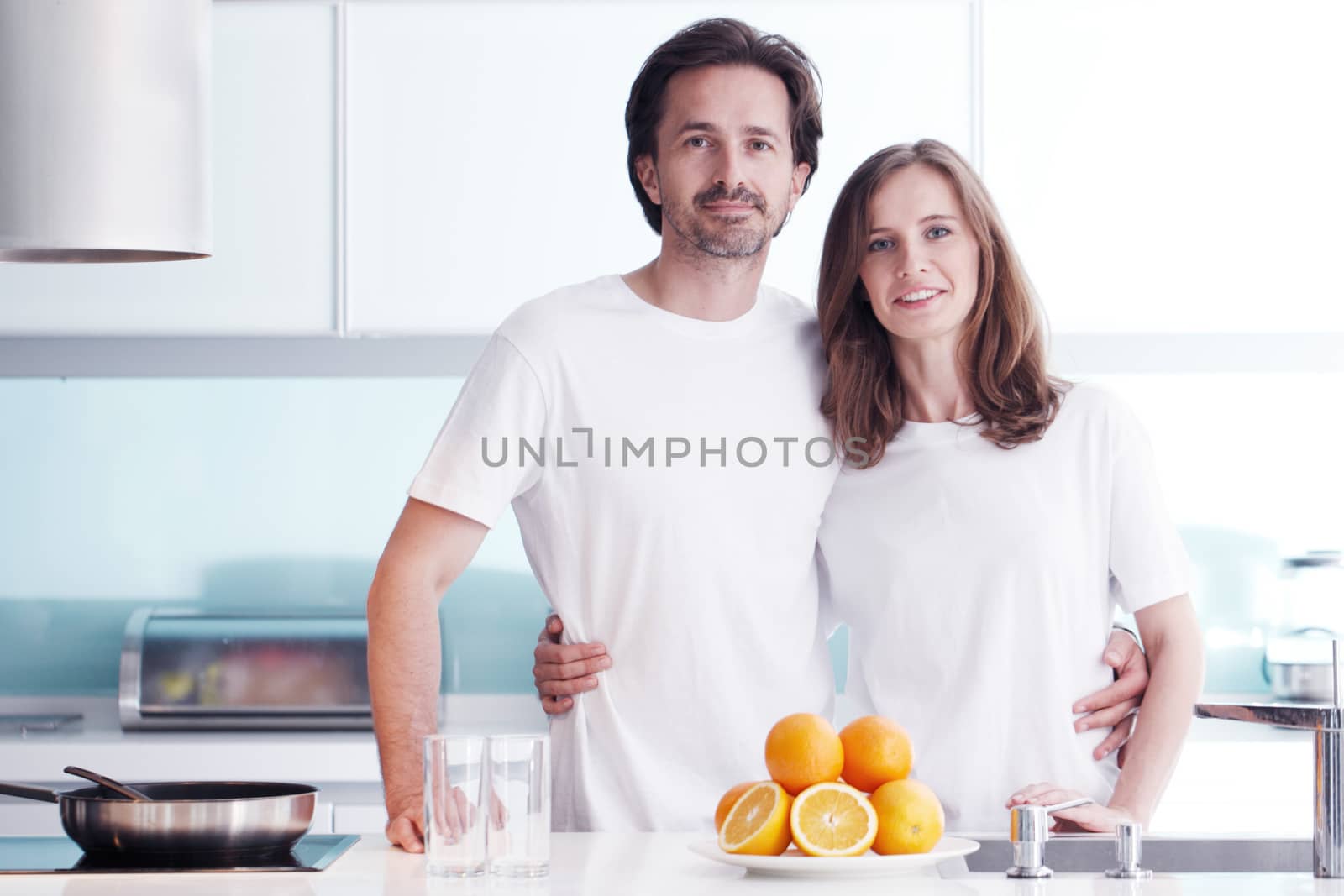 Couple with orange juice in the kitchen