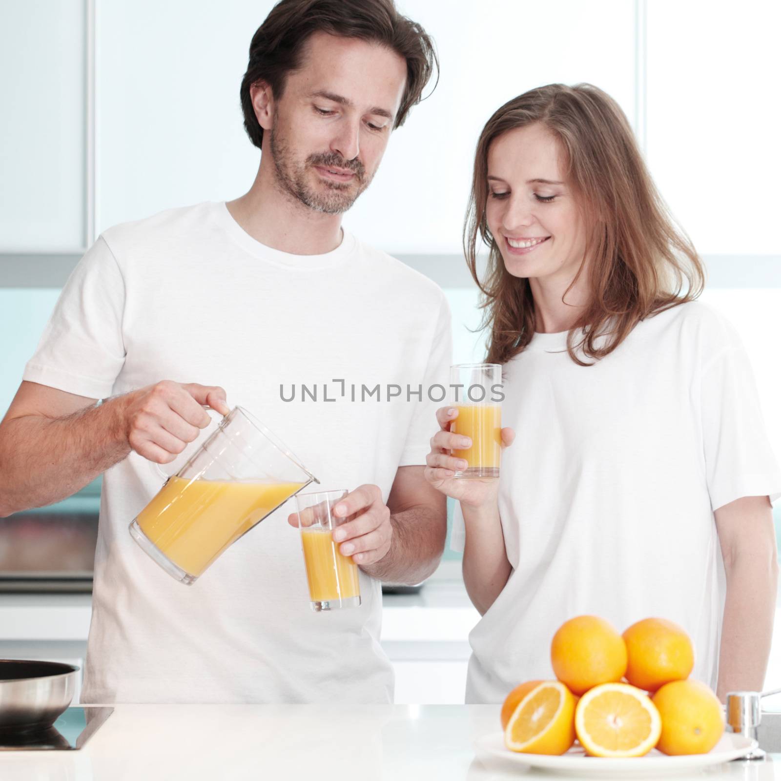 Couple with orange juice in the kitchen