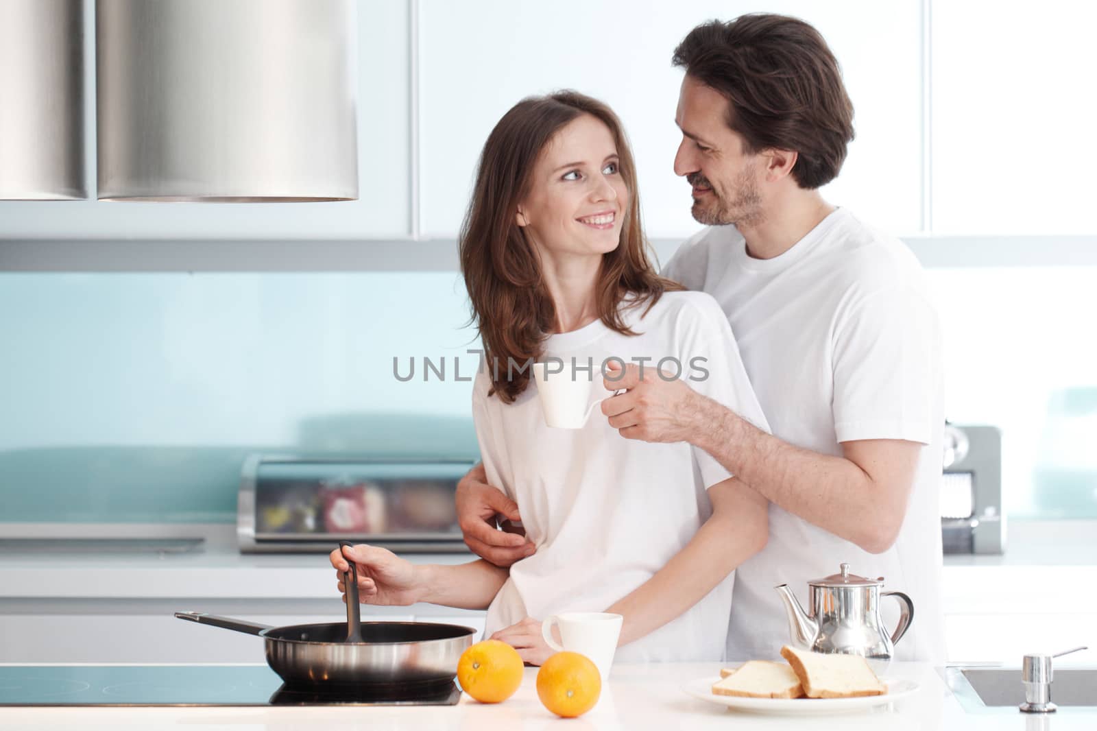 Happy couple cooking breakfast together in the kitchen