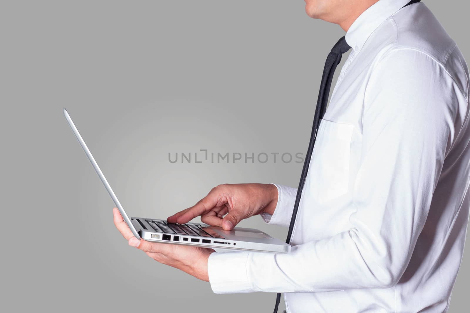 business man holding a laptop working on a gray background.