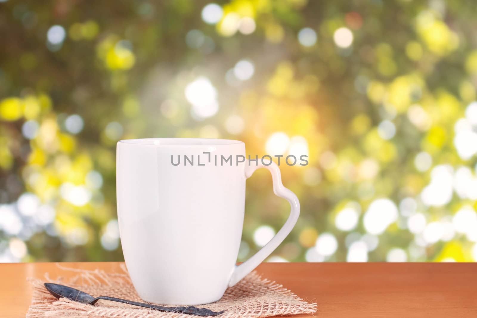 cup of hot coffee on wooden floor with bokeh background.