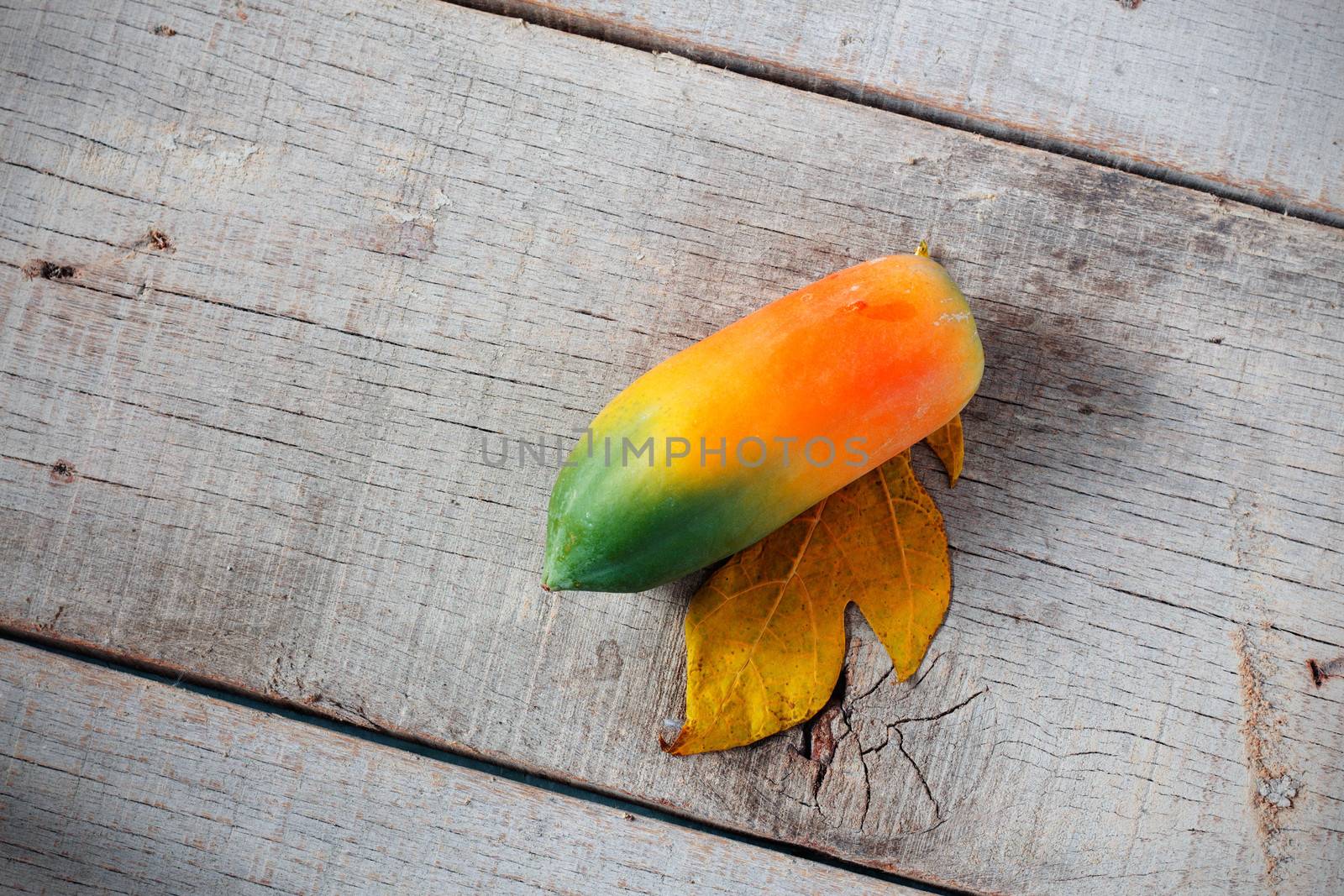 Papaya is ripe on old wooden floor with top view.