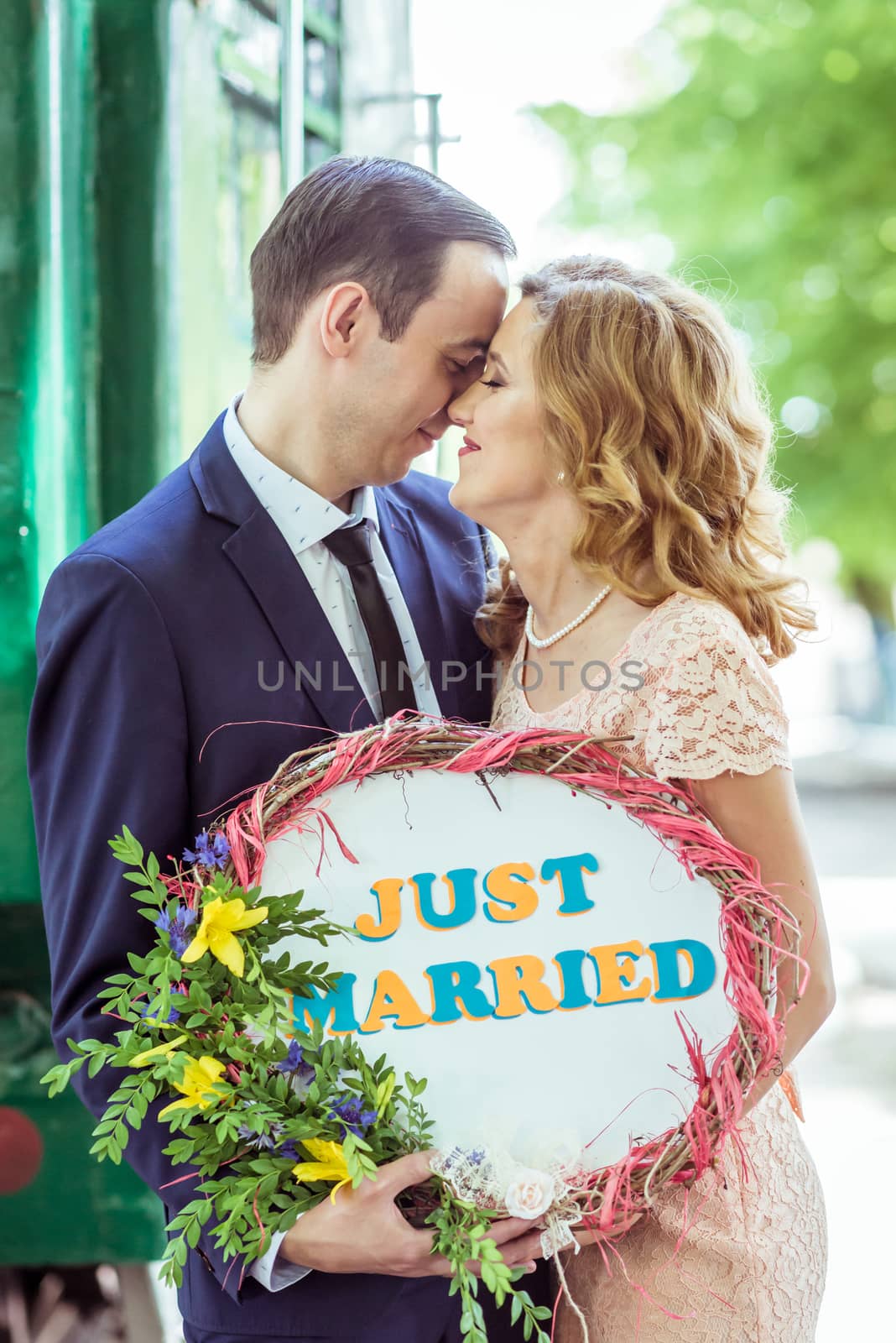 Close up portrait of loving couple. Man and woman standing near the wagon with a sign just married in Lviv Ukraine