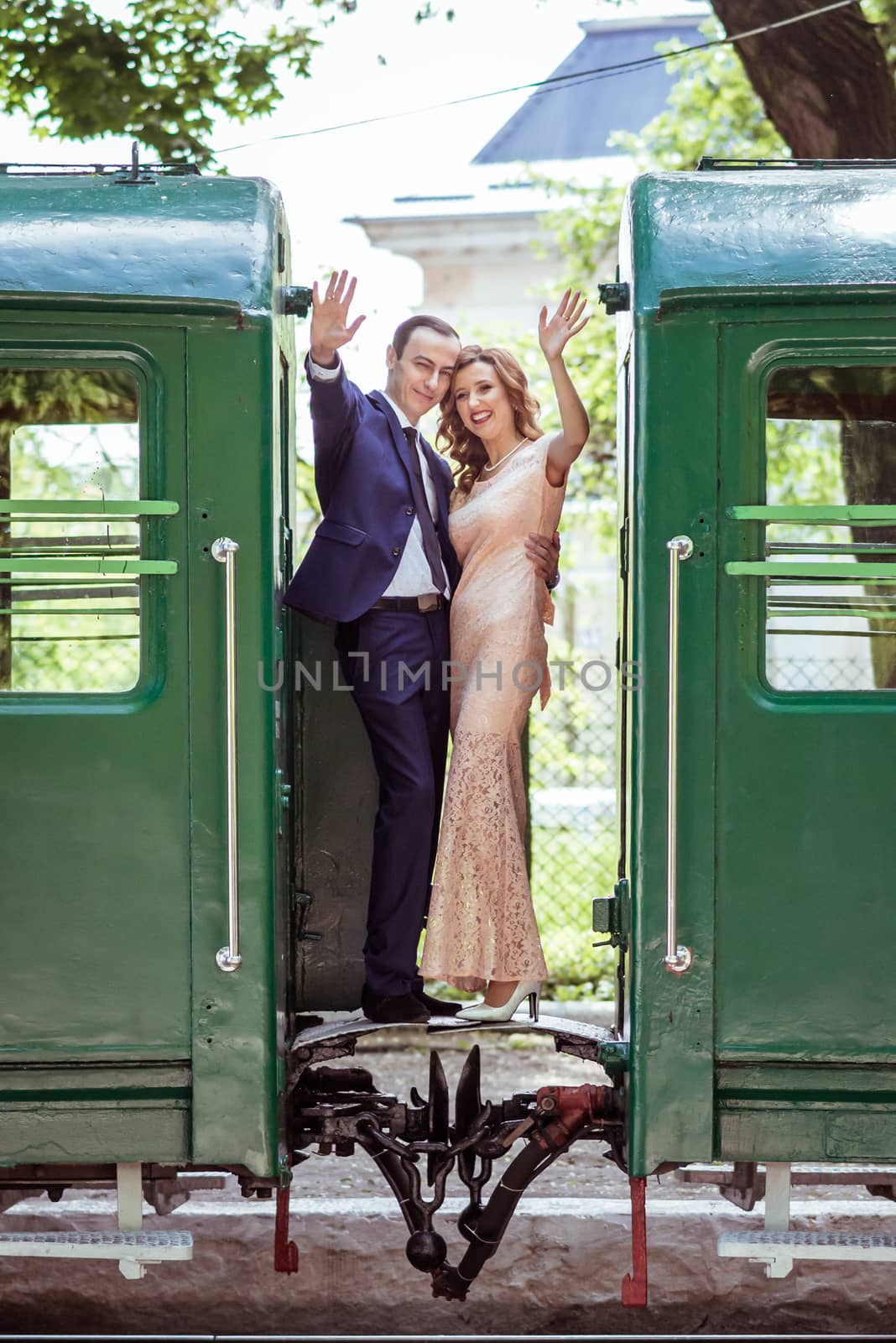 Just married couple standing at the junction between by wagons in Lviv, Ukraine