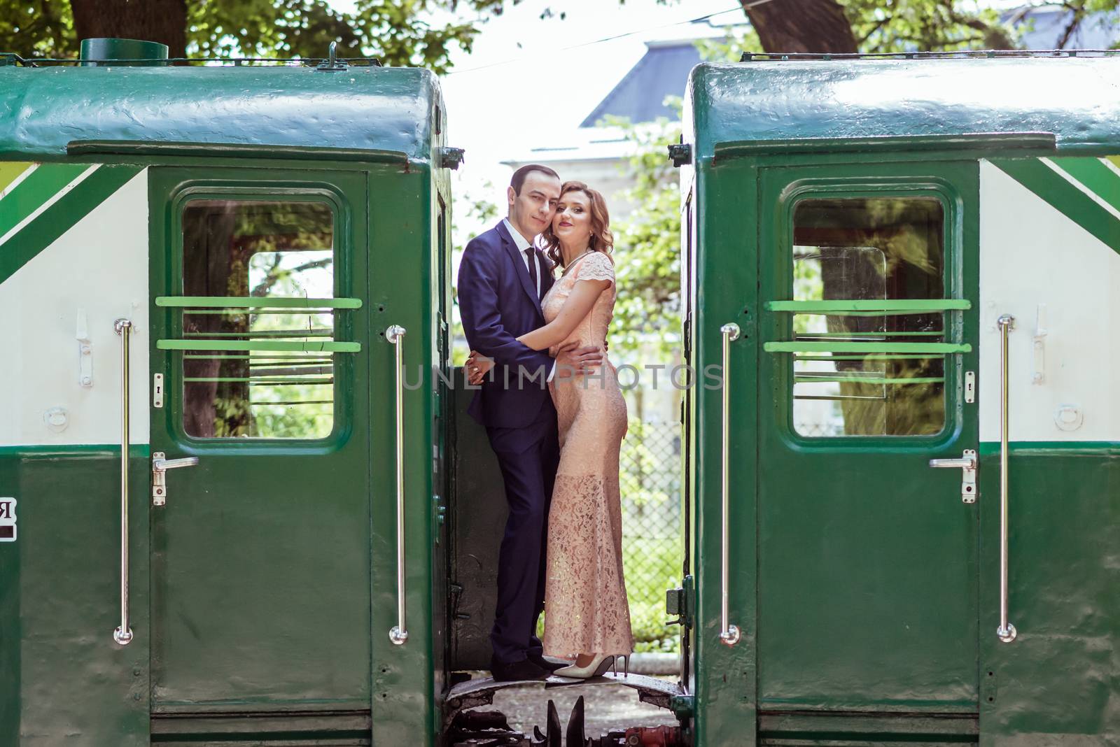 Just married couple standing at the junction between by wagons in Lviv, Ukraine