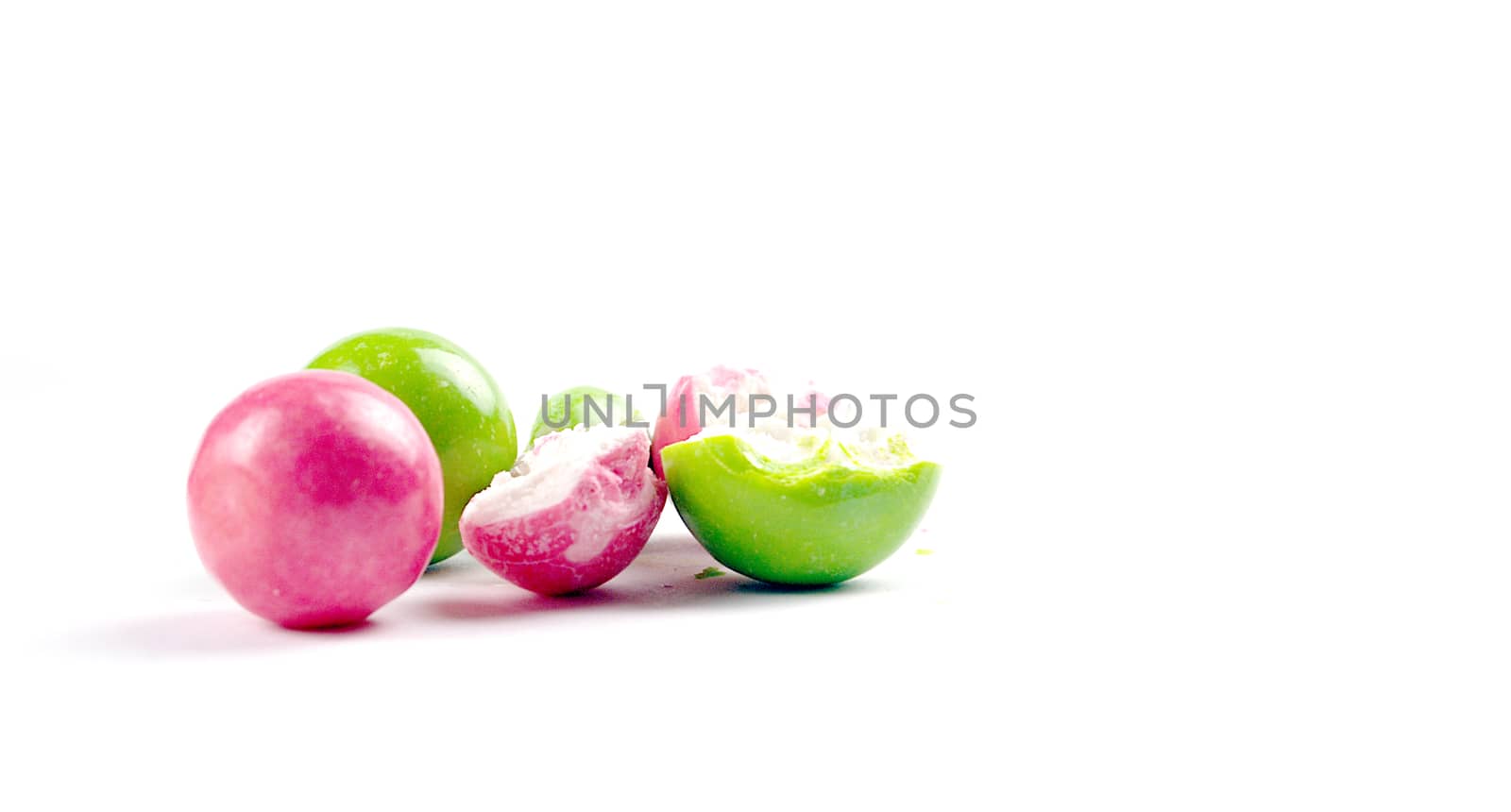 pink and green gumballs on a white background.