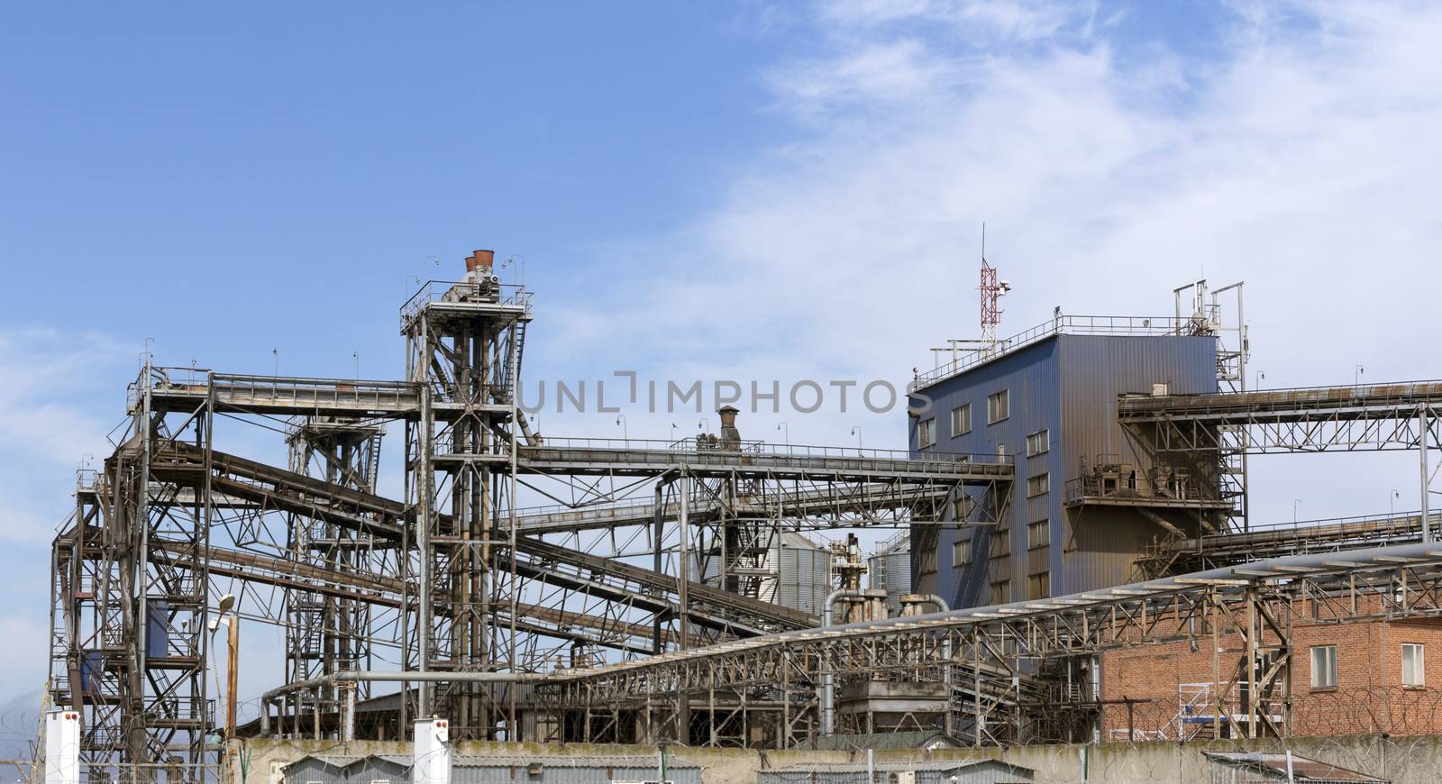 Pipes oil refining factory against a blue sky.