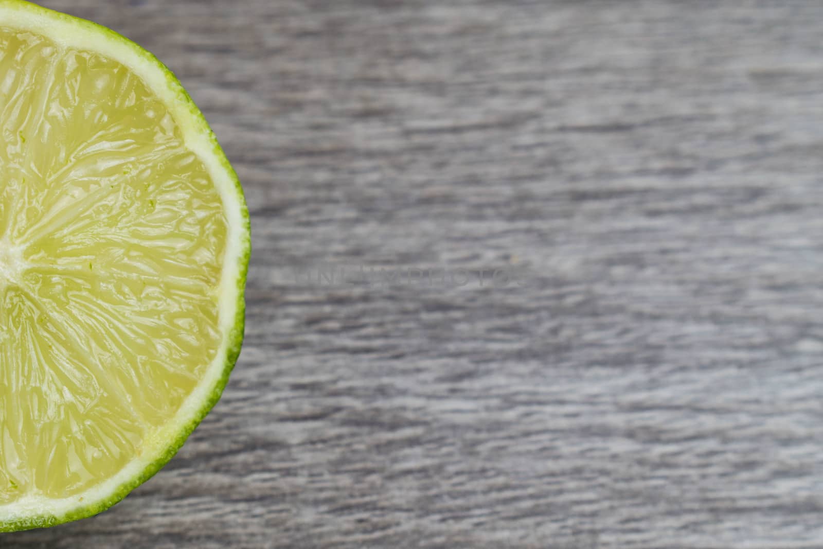 Slice of lime in a wooden bacground