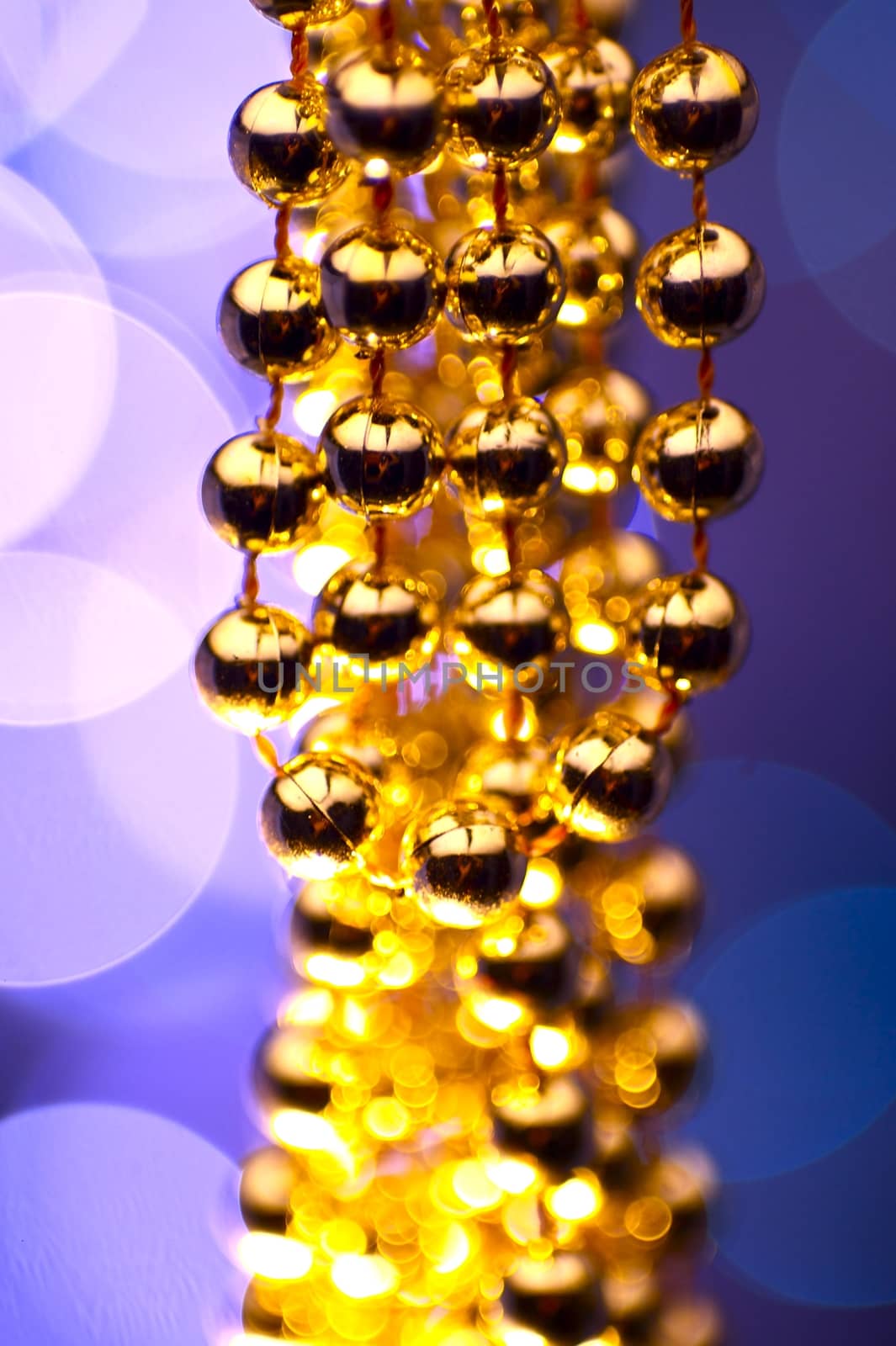 Golden Christmas Ornaments - Bokeh Lights in the Background. Violet-Blue Background.