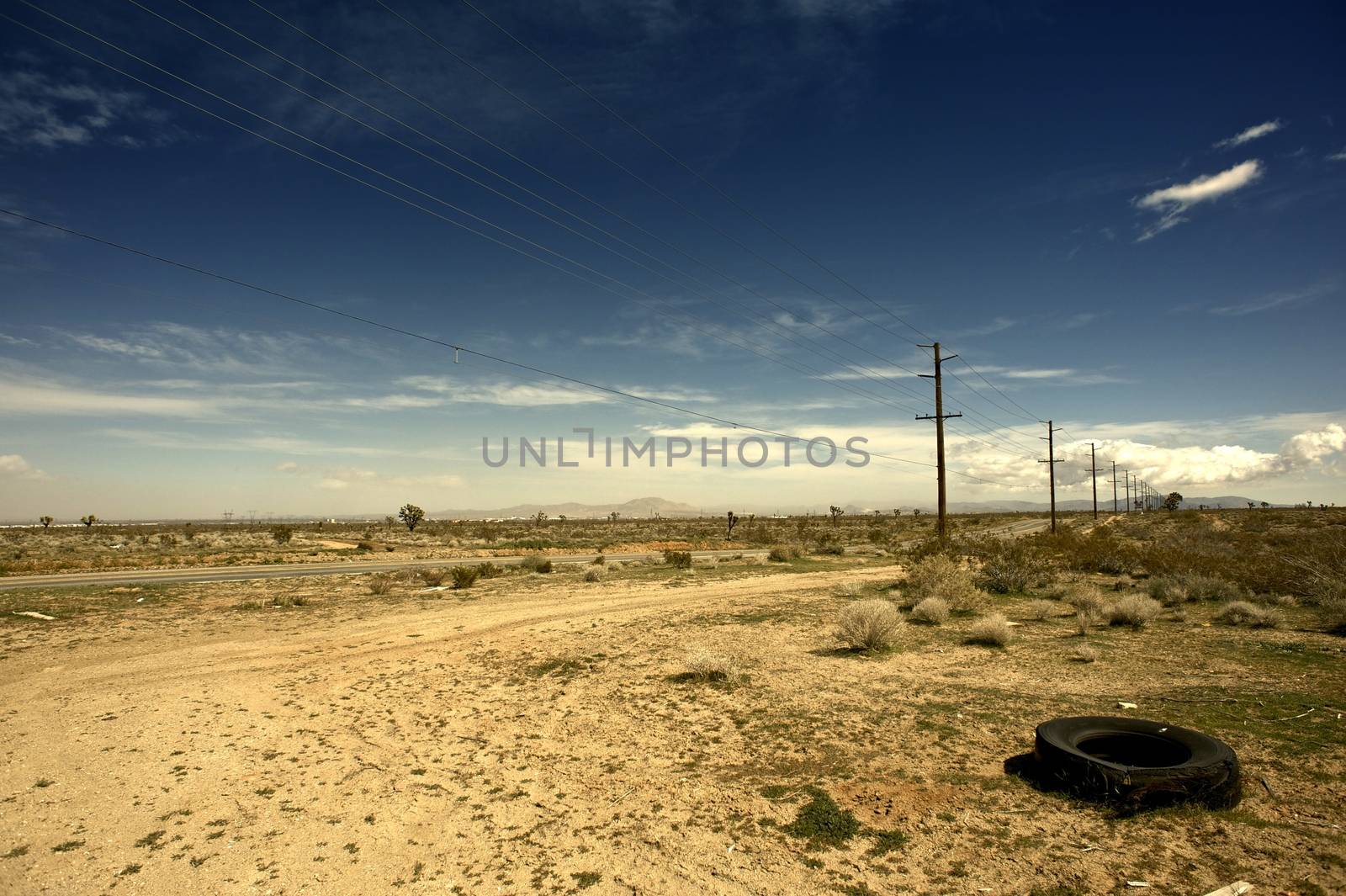 Outback California USA - California Suburbs Desert Landscape with Old Broken Tire on the Road Side.