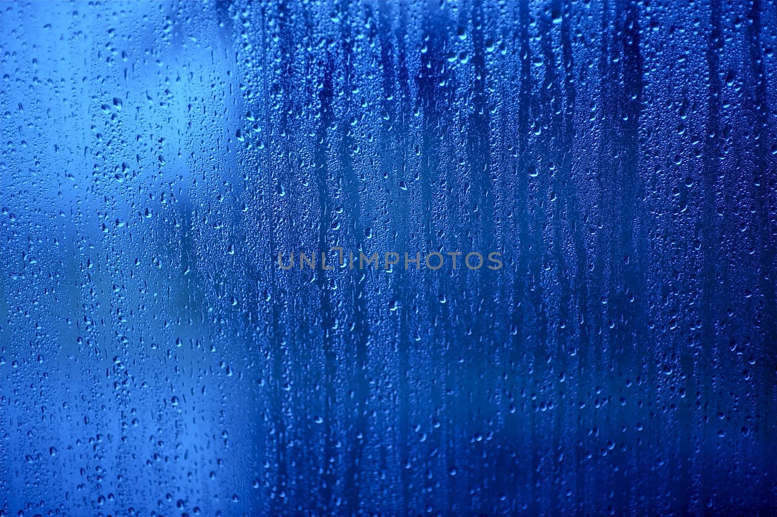 Wet Glass. Water Drops on the Blue Glass - Background, Texture