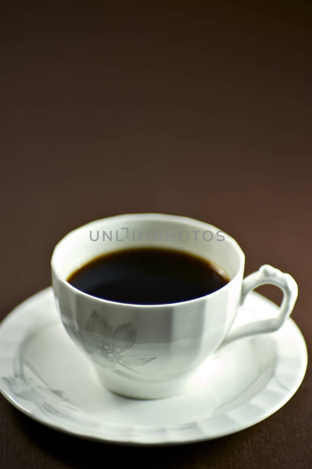 Black Coffee Cup. White Coffee Cup and Dark Brown Background.