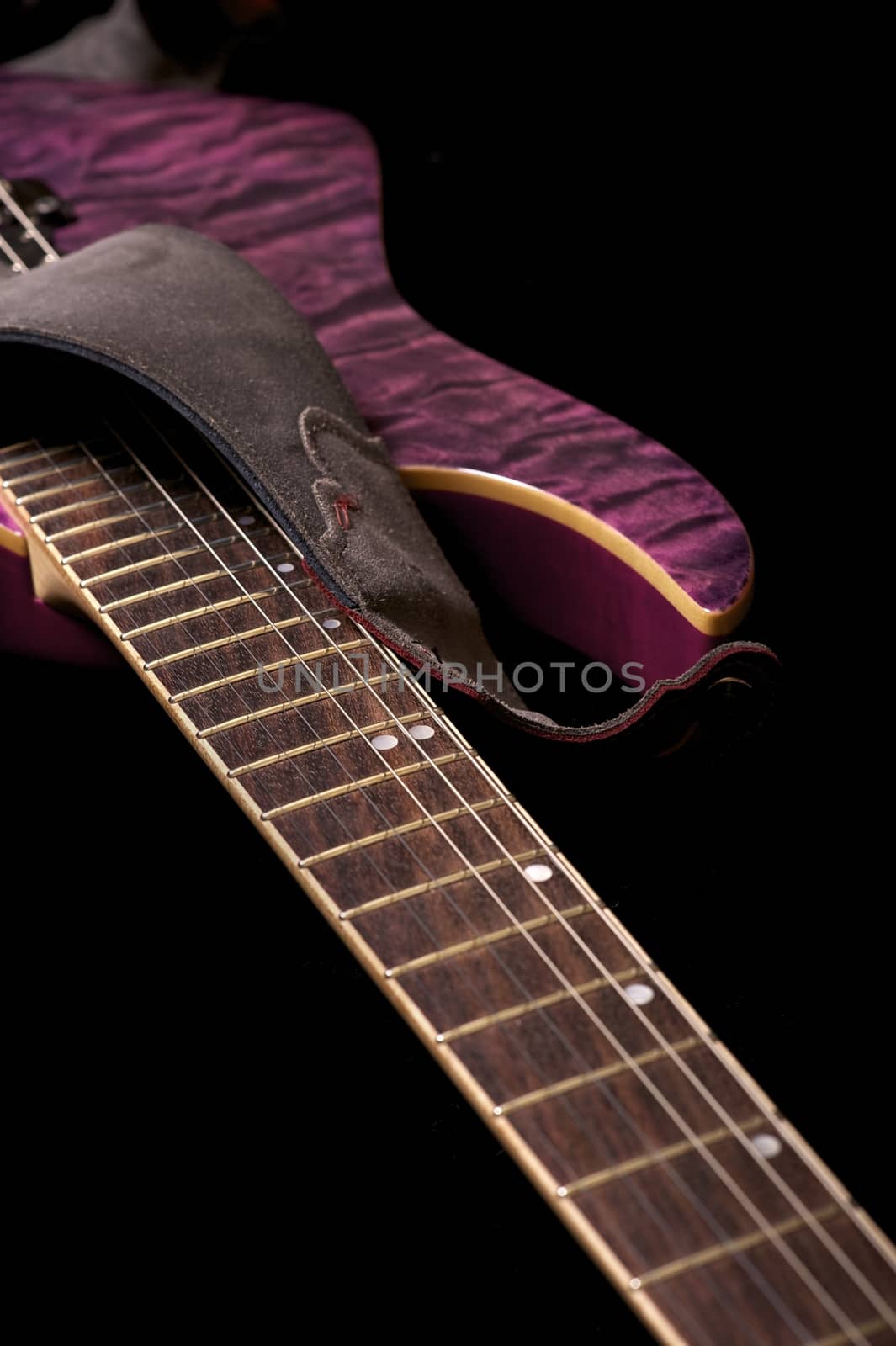 Purple Electric Guitar on Black Background. Part of the Guitar. Vertical Photo.