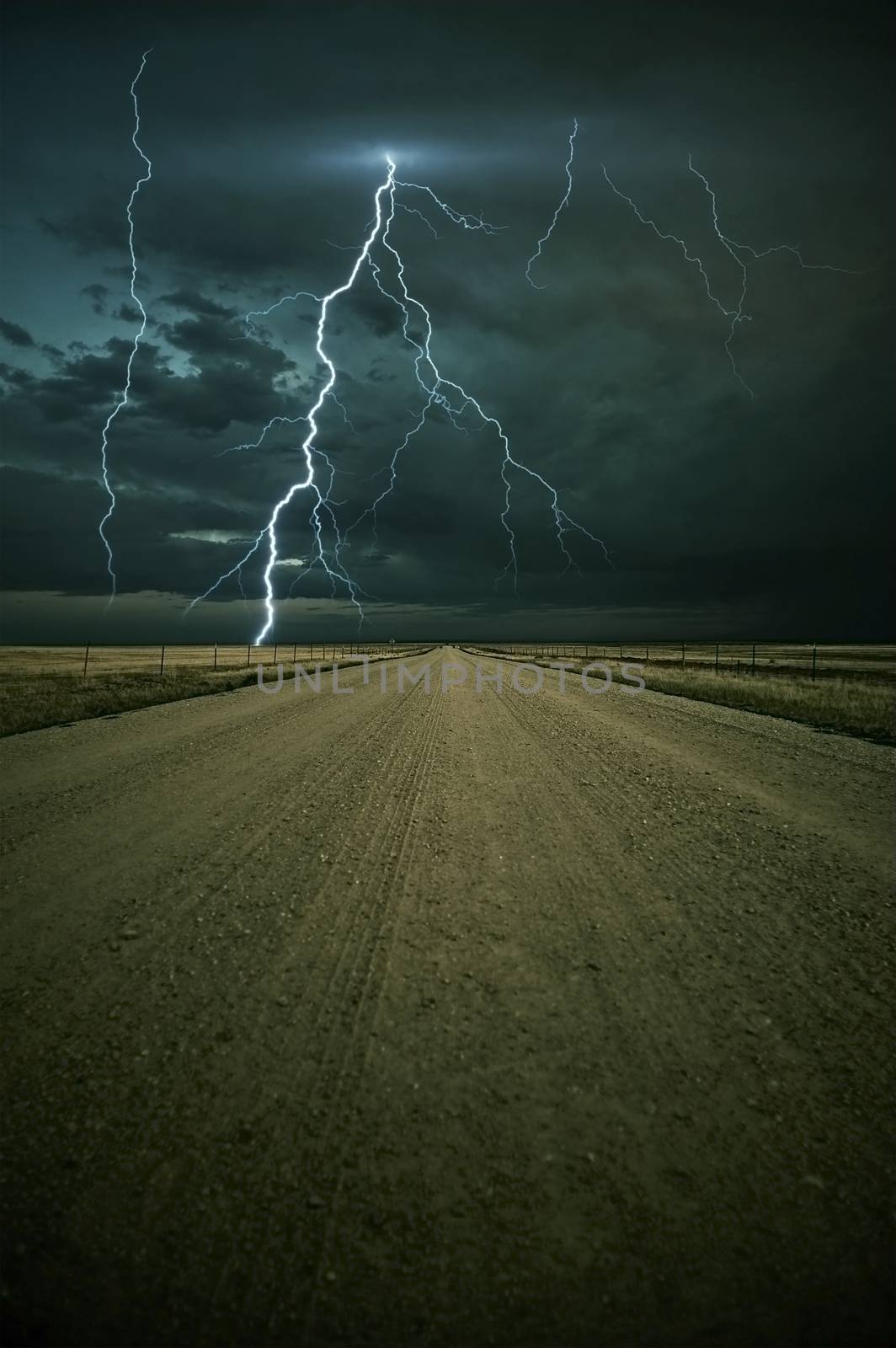 Lightning Storm Ahead - Colorado Plains Outback Road with Lightning Storm Ahead. Vertical Image. Nature Photo Collection.