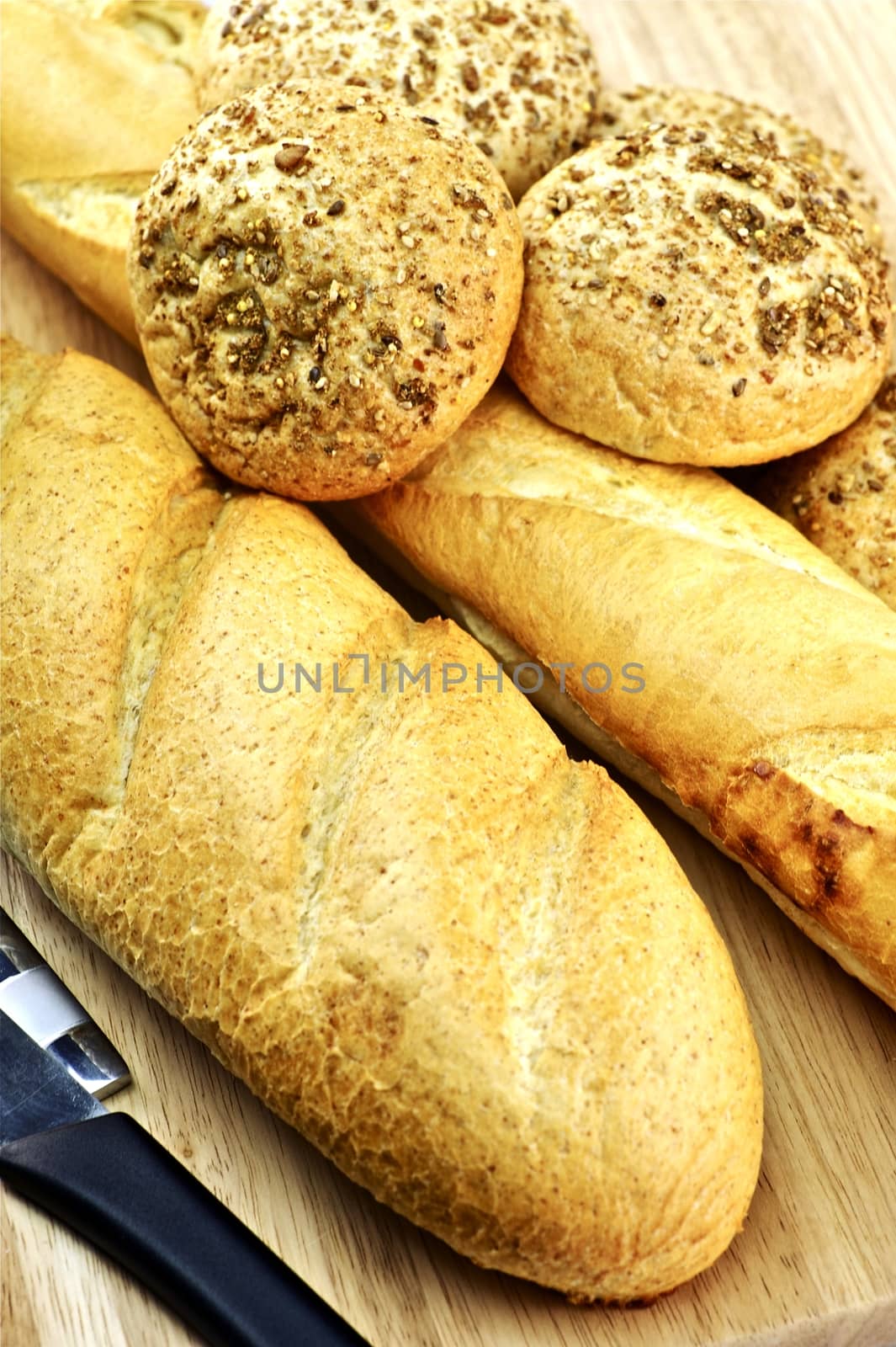 Fresh Baked Breads and Rolls. Wood Table and Knife. Tasty Morning Bread.