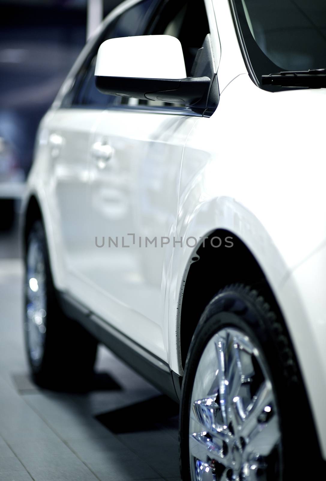 Side of the White Vehicle in Dealer Showroom. White SUV for Sale. Vertical Photo