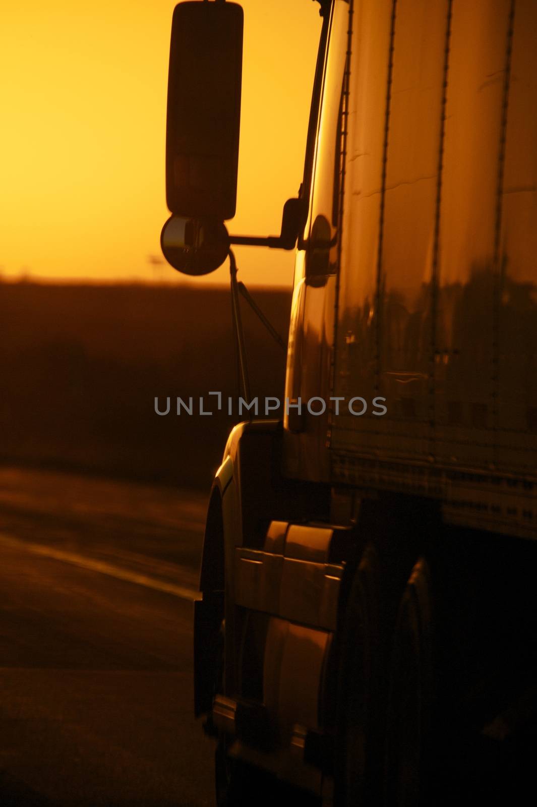 Sunset Highway. Truck on the Highway - Sunset. Vertical Photo. Heavy Long Distance American Transportation.