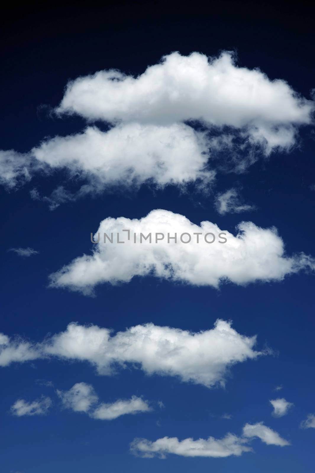 Cloud Layers - Dark Blue Sky with Few Clouds on Top of Each Other. Vertical Photography
