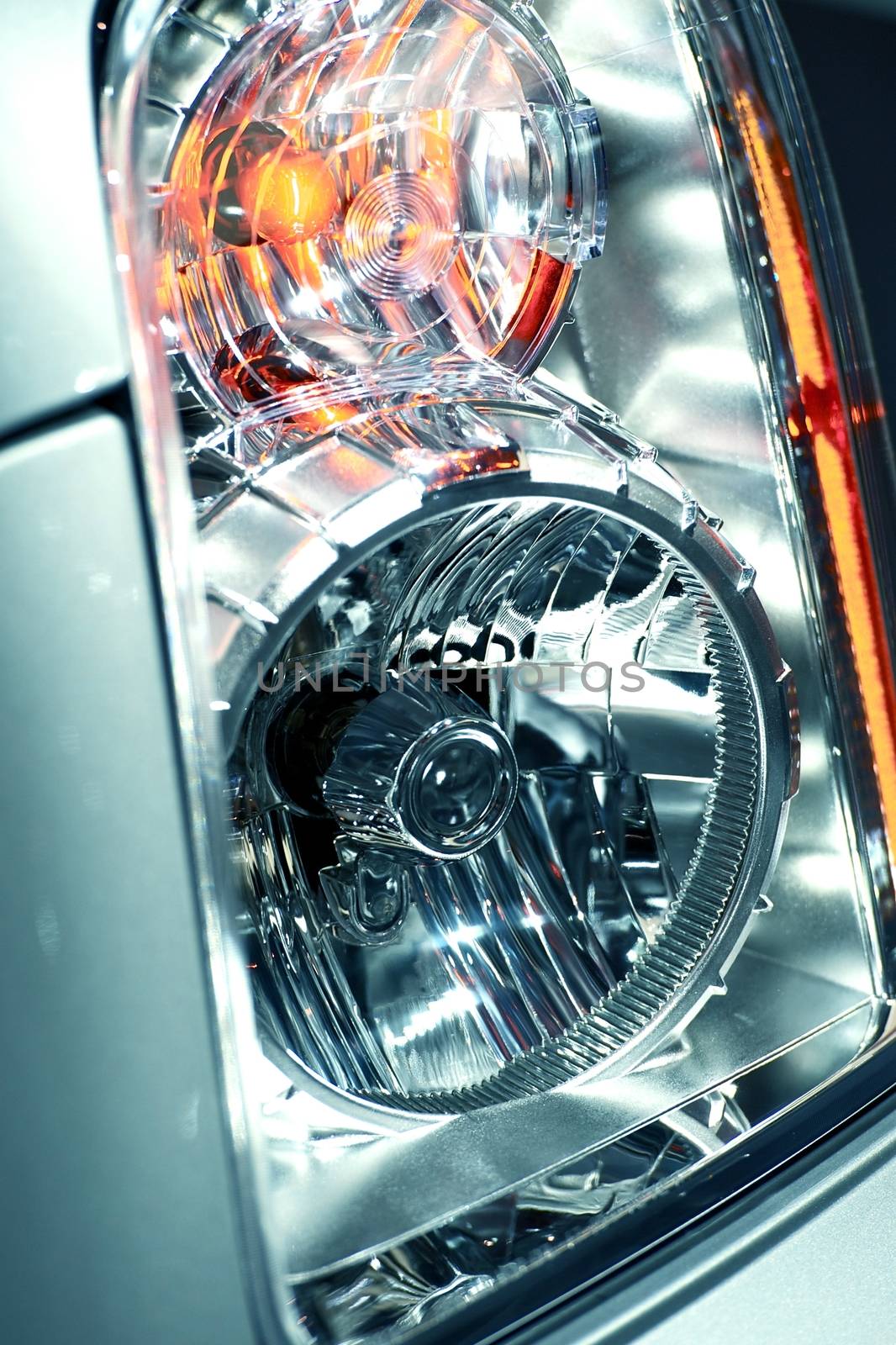 Modern Lens Car Headlight of SUV. Extreme Headlight Closeup - Vertical Photography.